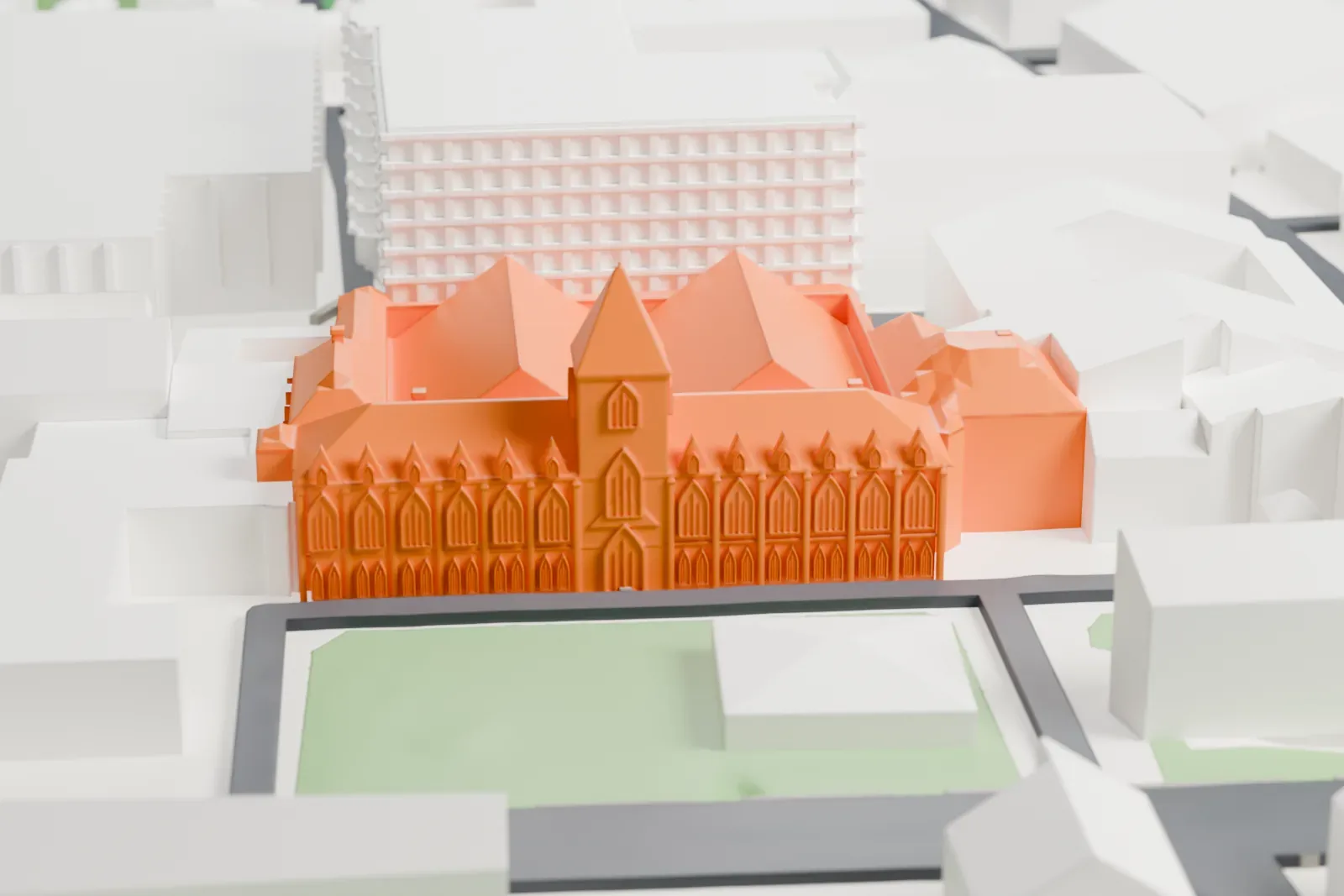 A white 3D print of the Oxford University Museum of Natural History, a low building with pointed windows, steep roofs and a small tower, beside lawns, streets and nearby buildings.
