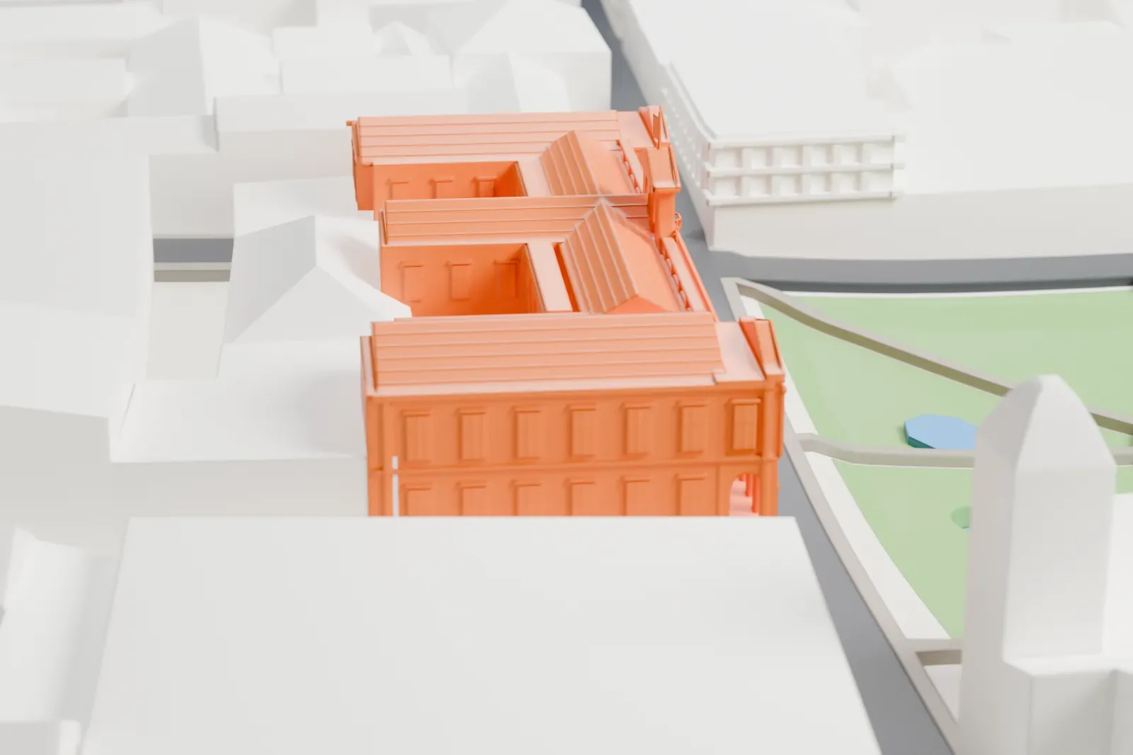 A white 3D print of Palacio de Carondelet, a palace of pitched-roof wings with arched windows, beside a green space and among surrounding buildings.