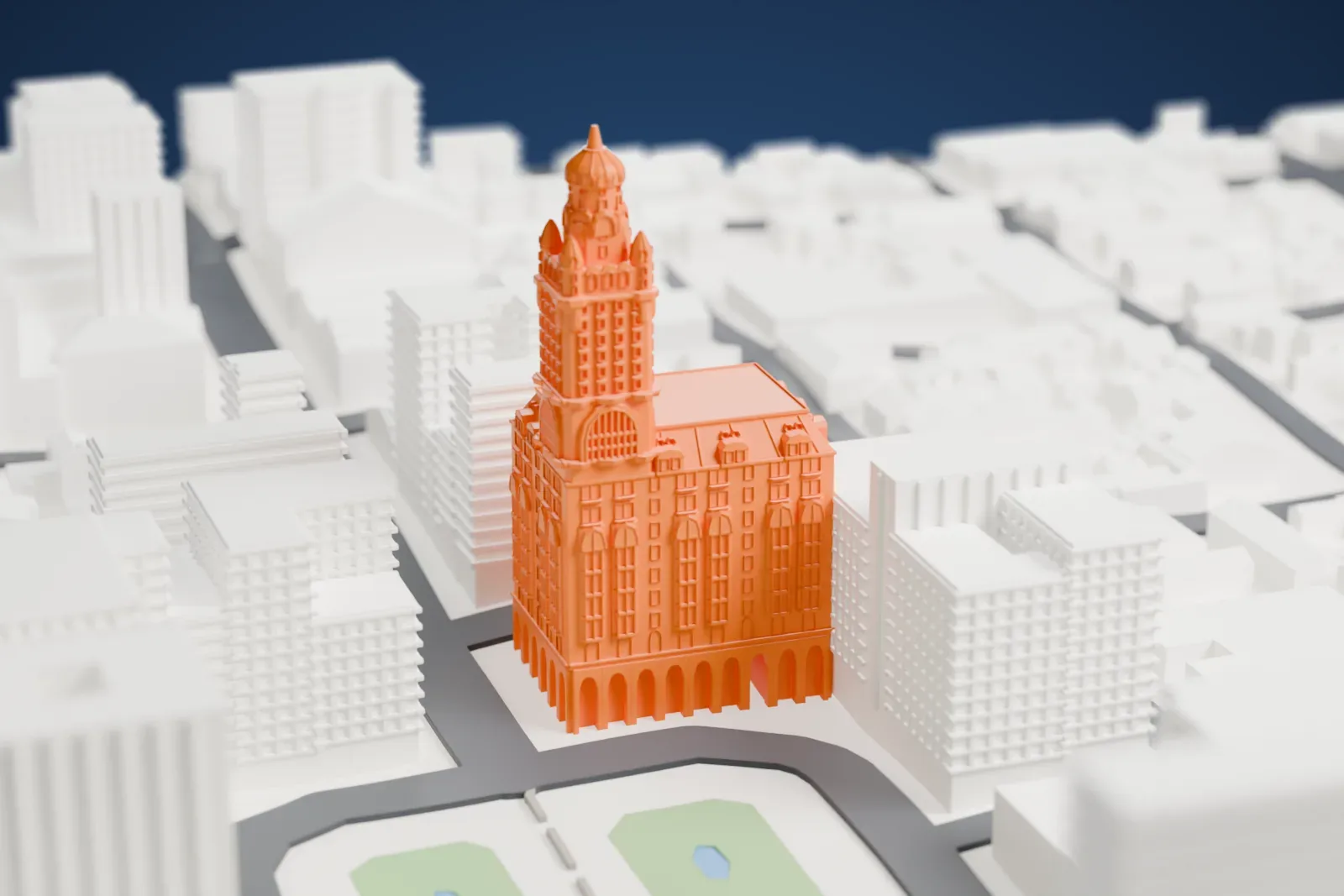 A white 3D print of Palacio Salvo, an ornate tower with small turrets and a domed spire rising from a broad base, with a green square and city blocks around it.