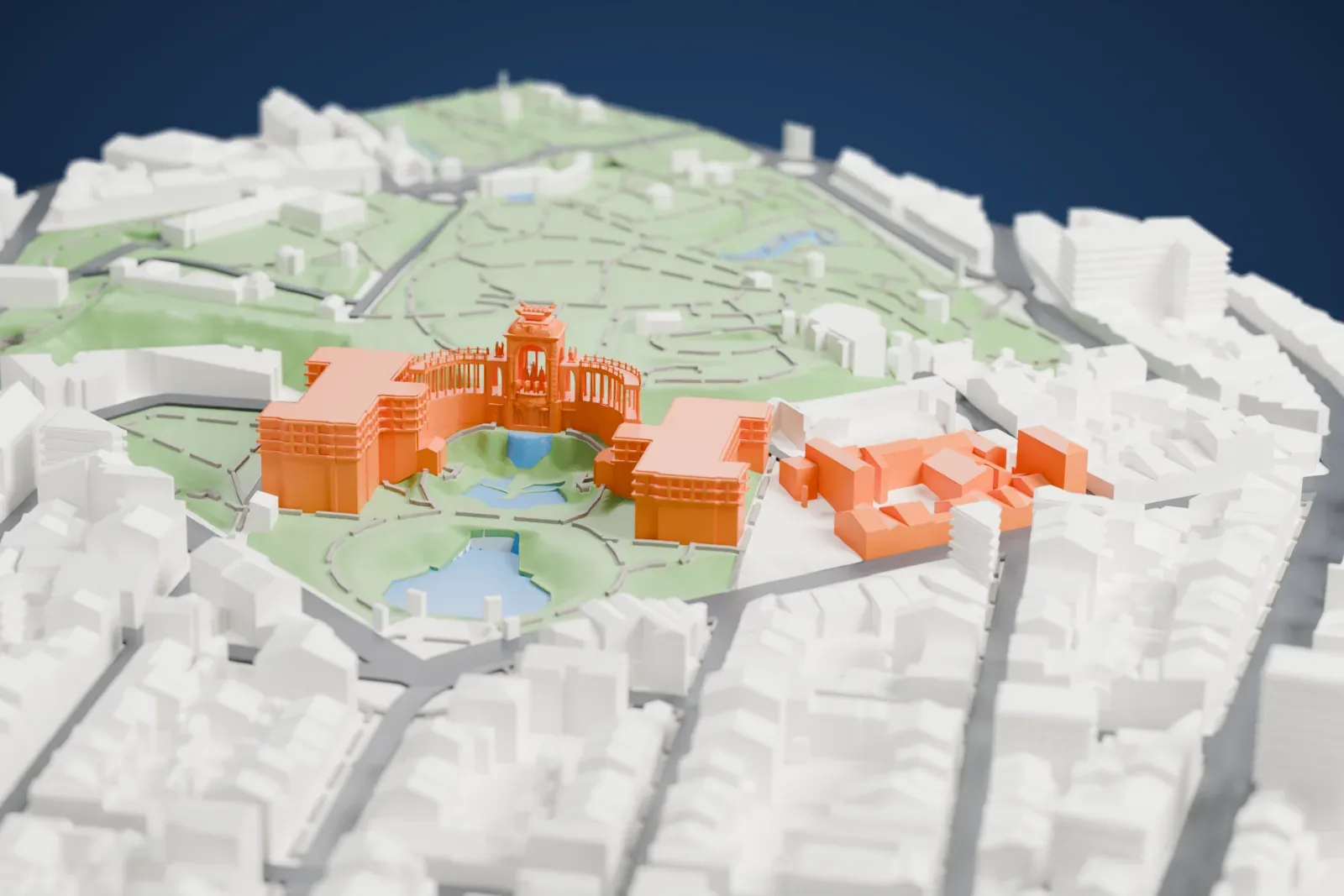 A white 3D print of the Palais Longchamp, an ornate central structure with a curved colonnade, set in green parkland with ponds and surrounded by gray buildings.
