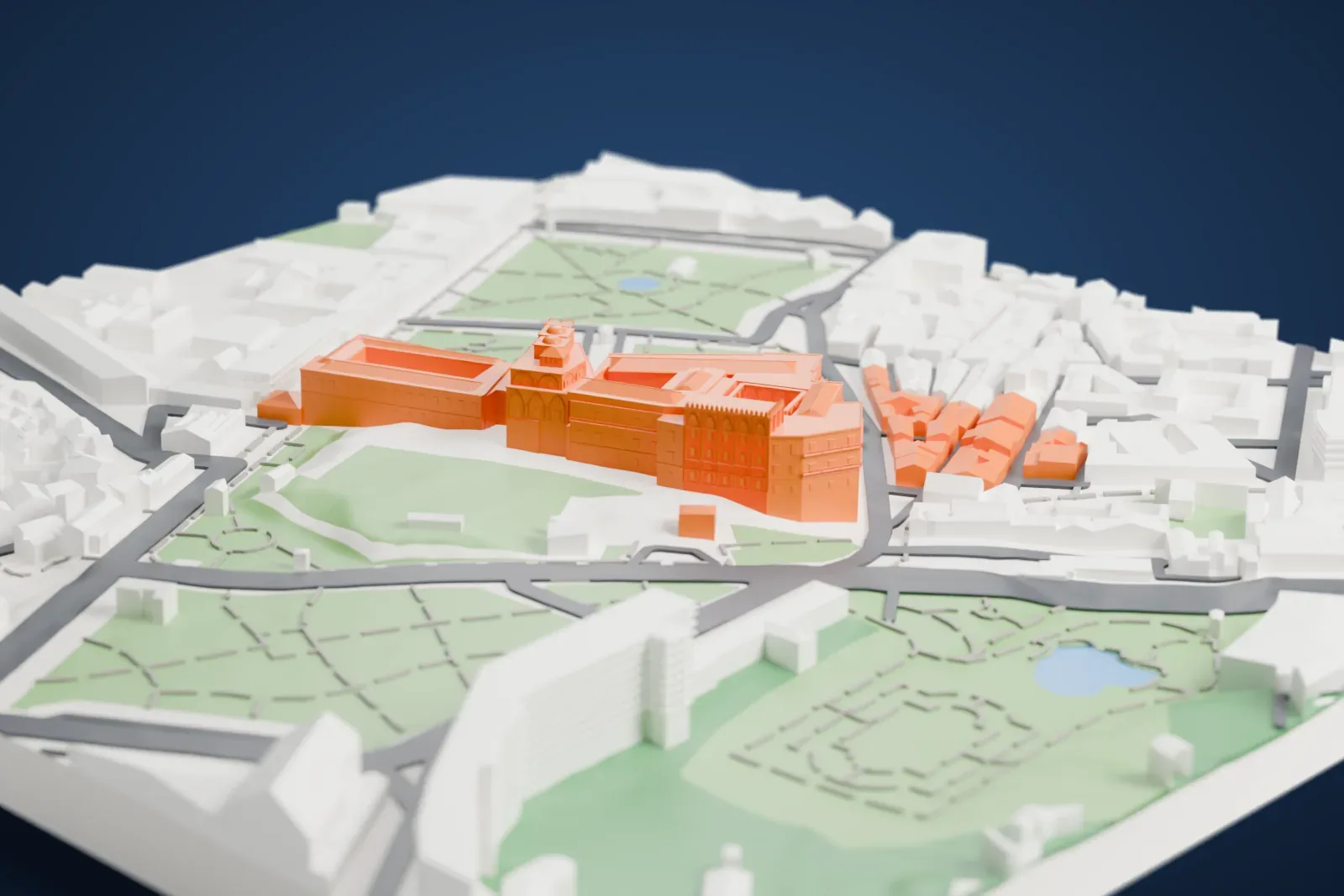 A white 3D print of the Palazzo dei Normanni, a large palace with open courtyards, a tower and small domes, standing beside park paths and the streets of Palermo.