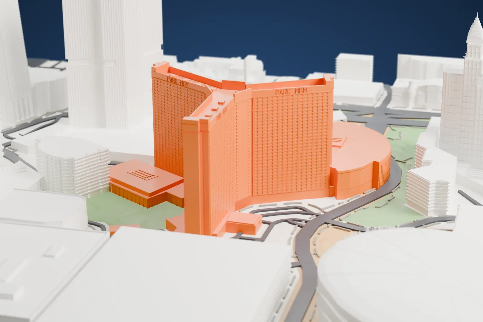 A white 3D print of Park MGM, a tall hotel tower with a round low building beside it, next to large round buildings and other buildings along wide roads.