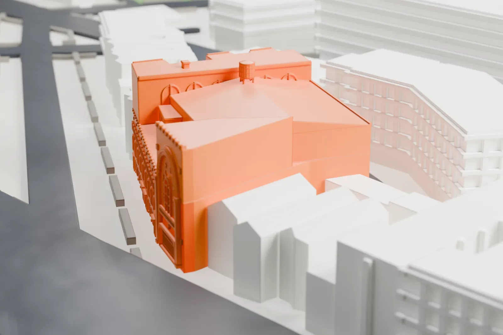 A white 3D print of the Parkway Theatre, a large block-shaped building with an arched front and a small rooftop tank, beside wide streets and neighboring buildings.