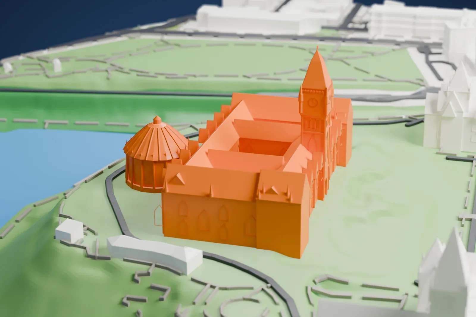 A white 3D print of Parliament Hill, three Gothic-style buildings, one with a tall central tower, on a green hilltop above a river, with city buildings beside it.