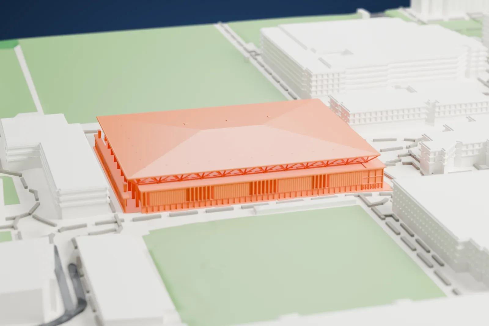 A white 3D print of the Pauley Pavilion with its broad roof and edge trusses, surrounded by buildings, paths, and open green areas.