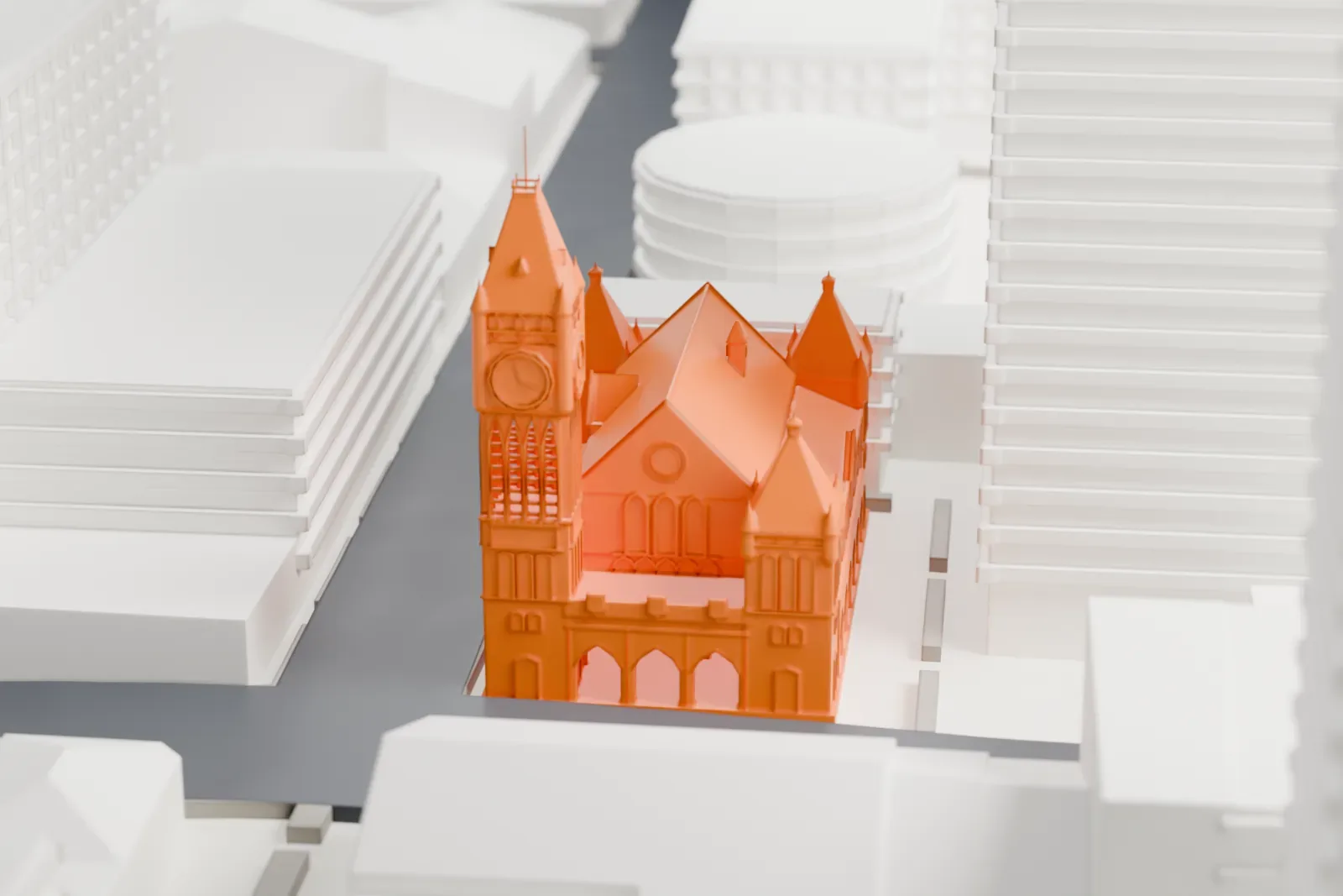 A white 3D print of Perth Town Hall, a Gothic-style building with a tall clock tower, pointed turrets and gabled roofs, set among taller buildings along city streets.