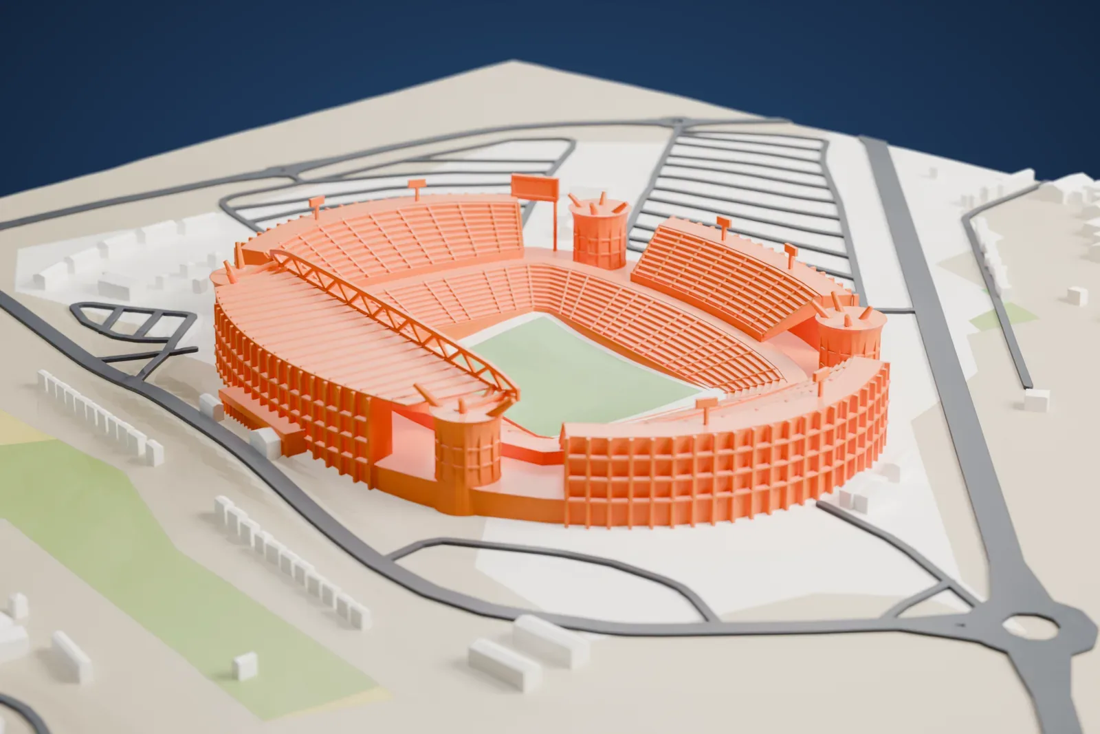 A white 3D print of the Peter Mokaba Stadium, an oval two-tier bowl with a roof over one stand and four round corner drums, on a base of surrounding streets and buildings.