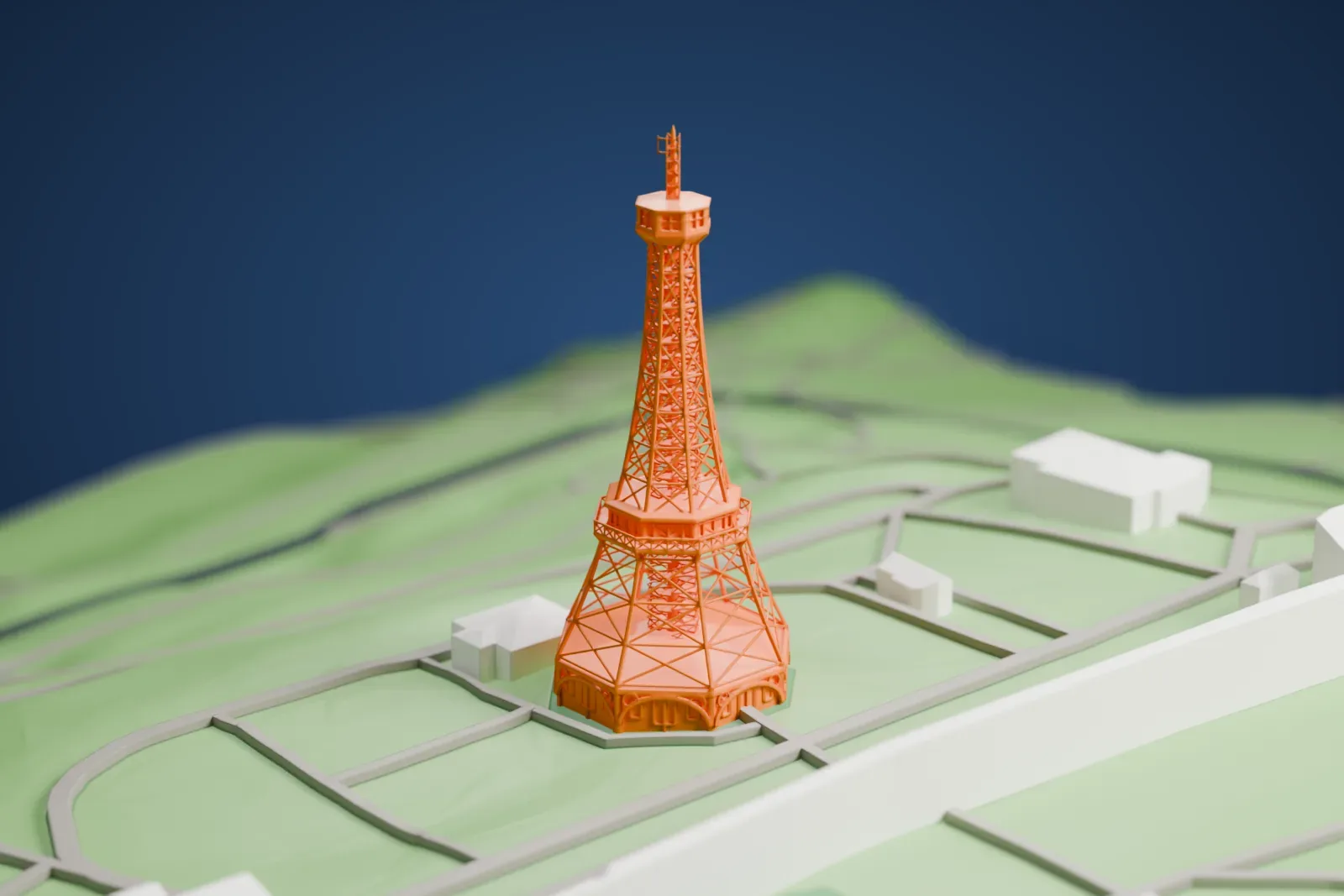 A white 3D print of the Petřín Lookout Tower, a slender steel-framework tower, standing on Petřín Hill among the surrounding streets and buildings.
