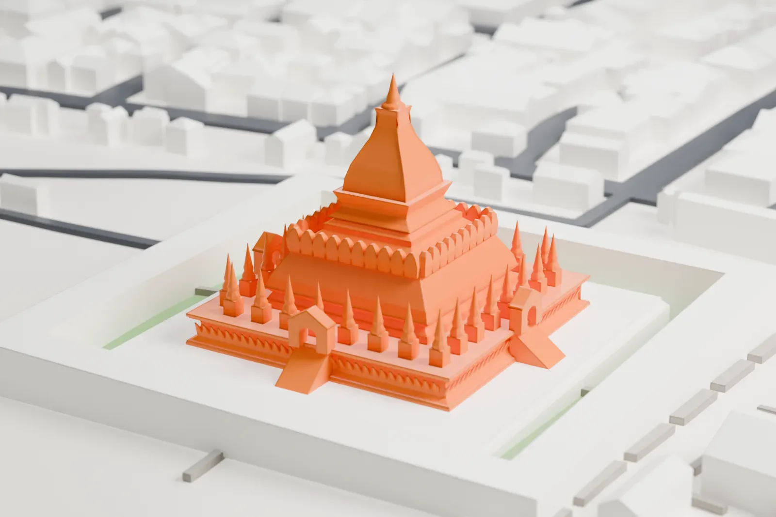 A white 3D print of Pha That Luang, a stepped stupa with a tapering central spire and rings of small spires inside a square wall, set among low buildings, streets and green lawns.
