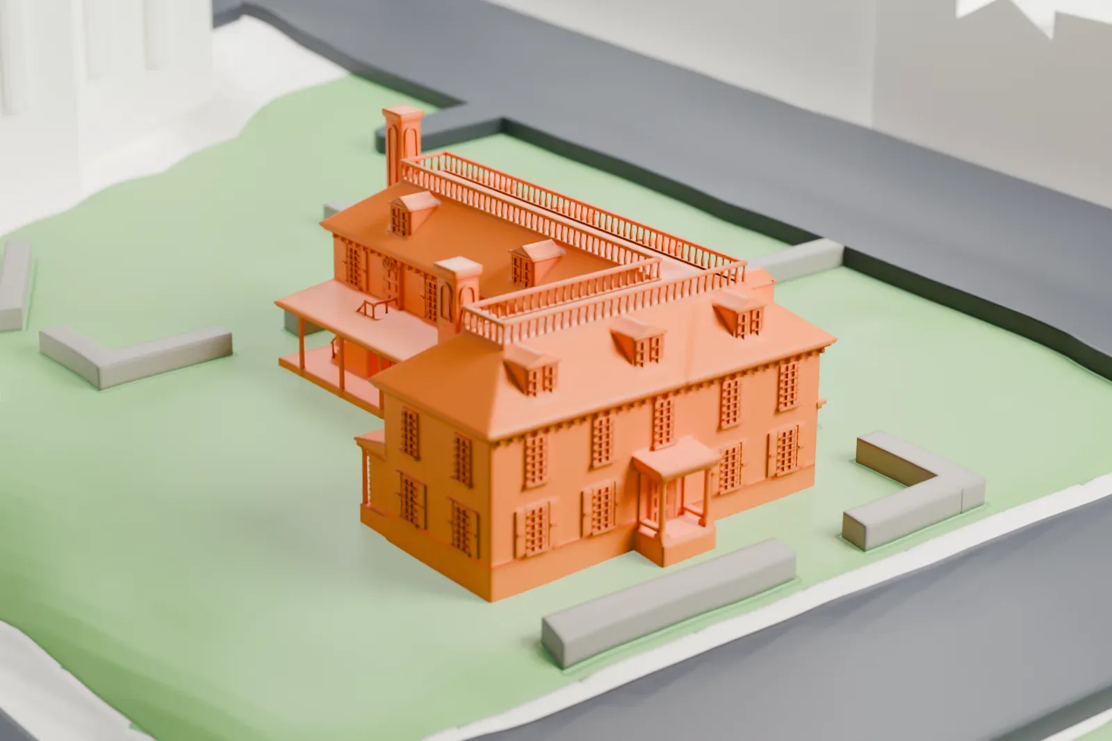 A white 3D print of Philipse Manor Hall, a two-story house with a roof balustrade, dormers and columned porches, standing on a lawn beside a road.