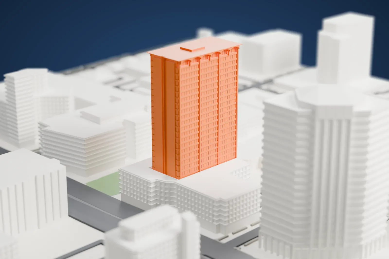 A white 3D print of Phoenix Corporate Center, a tall slab tower with shallow arches near the top, rising above lower blocks with wide roads and a small green plot nearby.