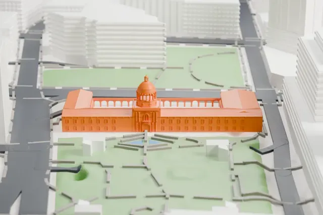 A white 3D print of the Pima County Courthouse model in Tucson, with the streets around it.