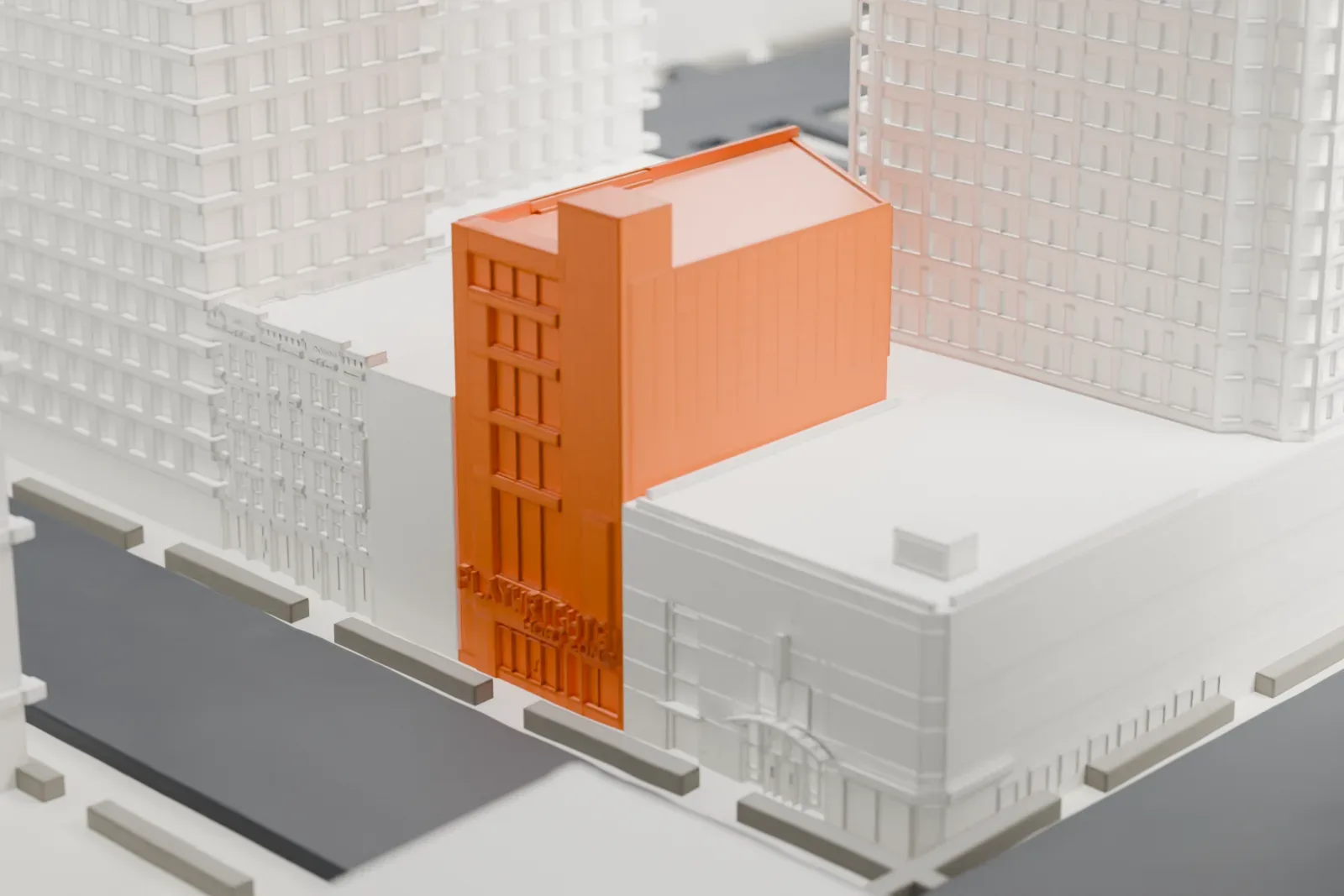 A white 3D print of Playwrights Horizons, a narrow building with lettering on its front, standing between taller buildings and a street.