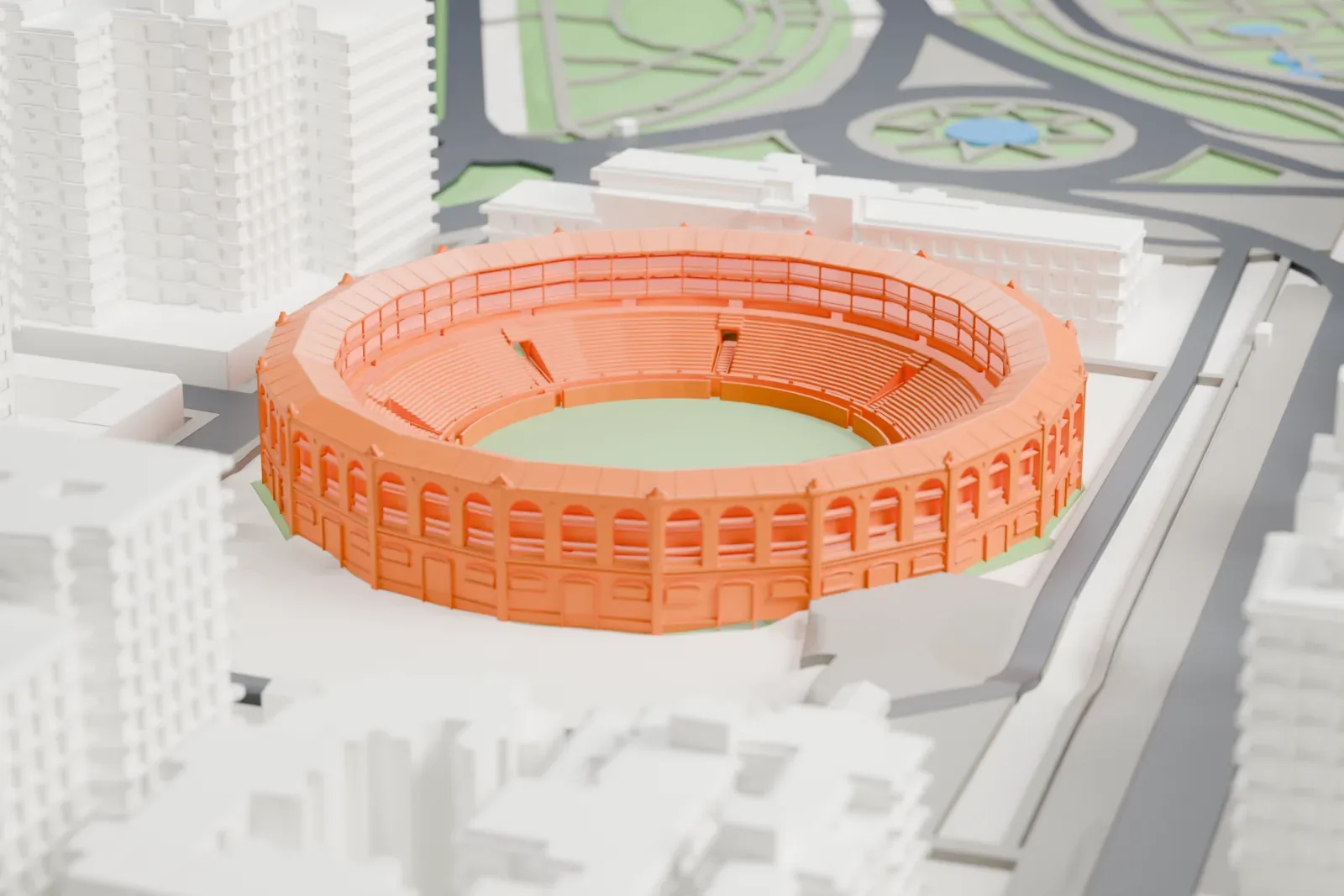 A white 3D print of Plaza de Toros de La Malagueta, a round arena with an arcaded wall and tiered seats, among dense city blocks and roads with hills nearby.