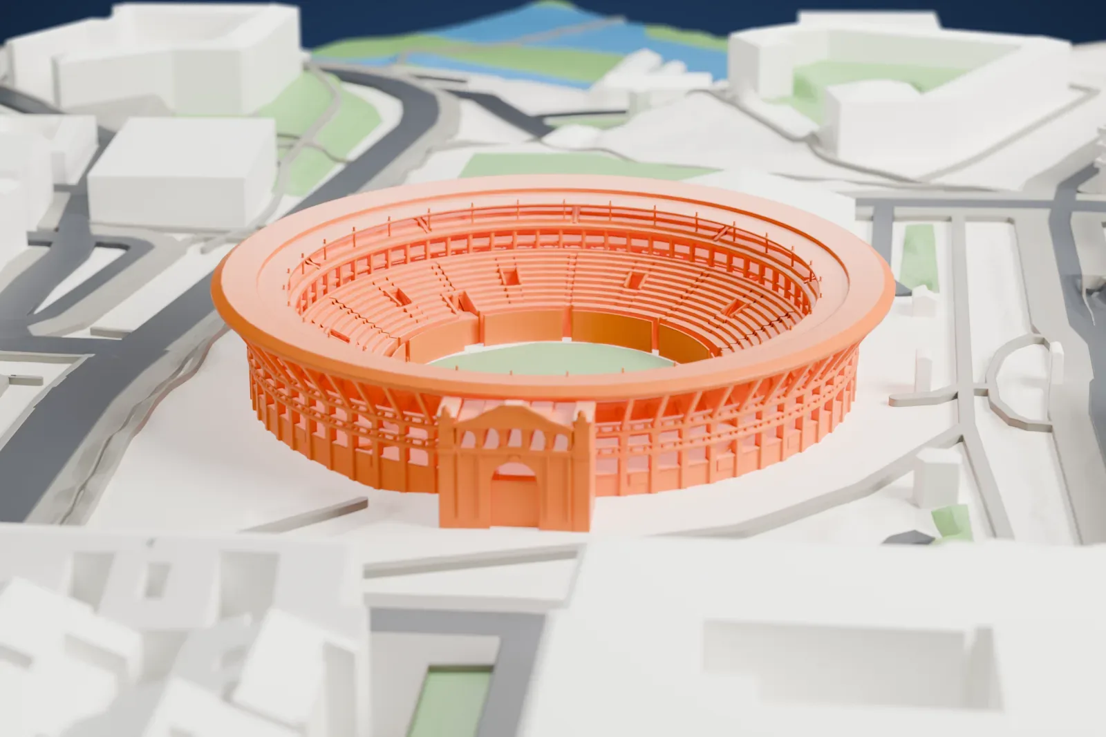 A white 3D print of Plaza de Toros de Pamplona, a round bullring with tiered seating and a decorated entrance gate, surrounded by city blocks and roads.