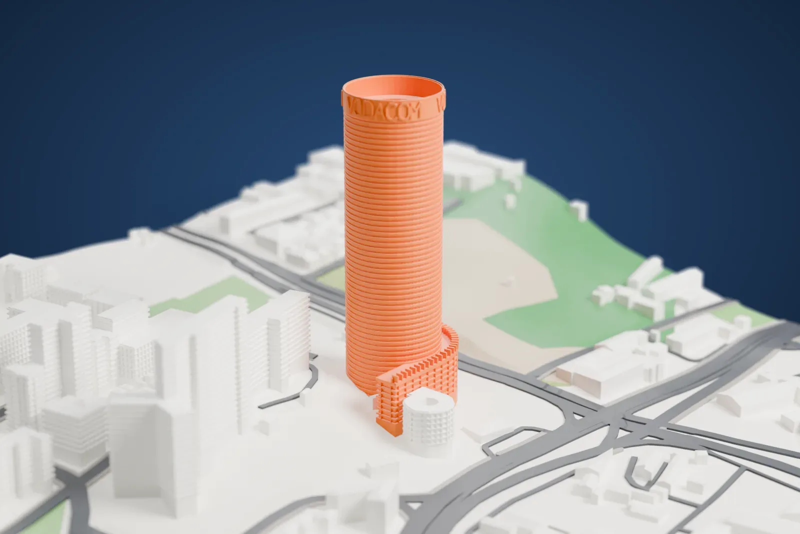 A white 3D print of Ponte City, a tall cylinder with an open center and a rooftop advertising drum, set among surrounding streets and buildings.