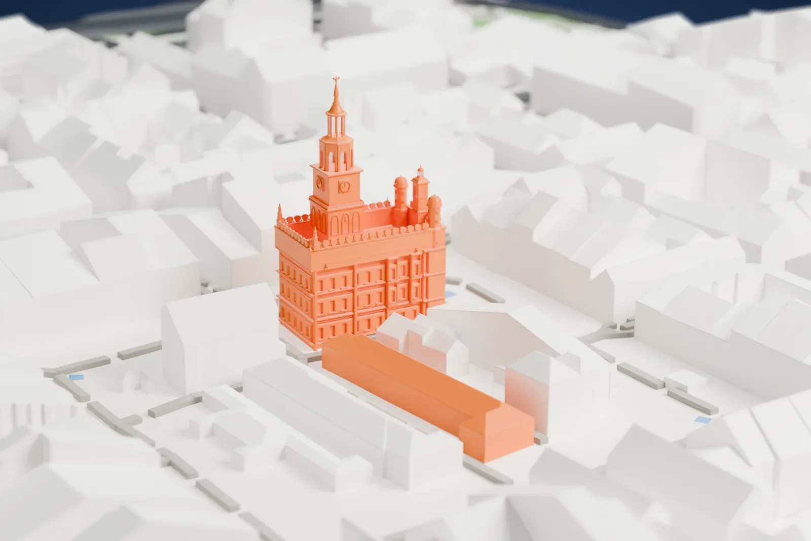 A white 3D print of Poznań Town Hall, a square building with a clock tower topped by an open lantern and spire, arcaded walls and corner turrets, surrounded by closely packed pitched-roof buildings.