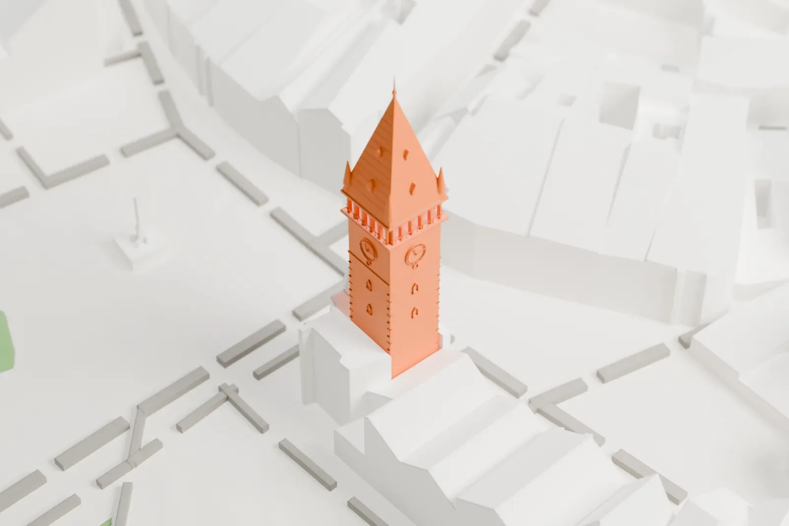 A white 3D print of the Prague astronomical clock tower, a tall square tower with clock faces, small corner turrets and a pointed spire, standing among dense buildings beside an open square.