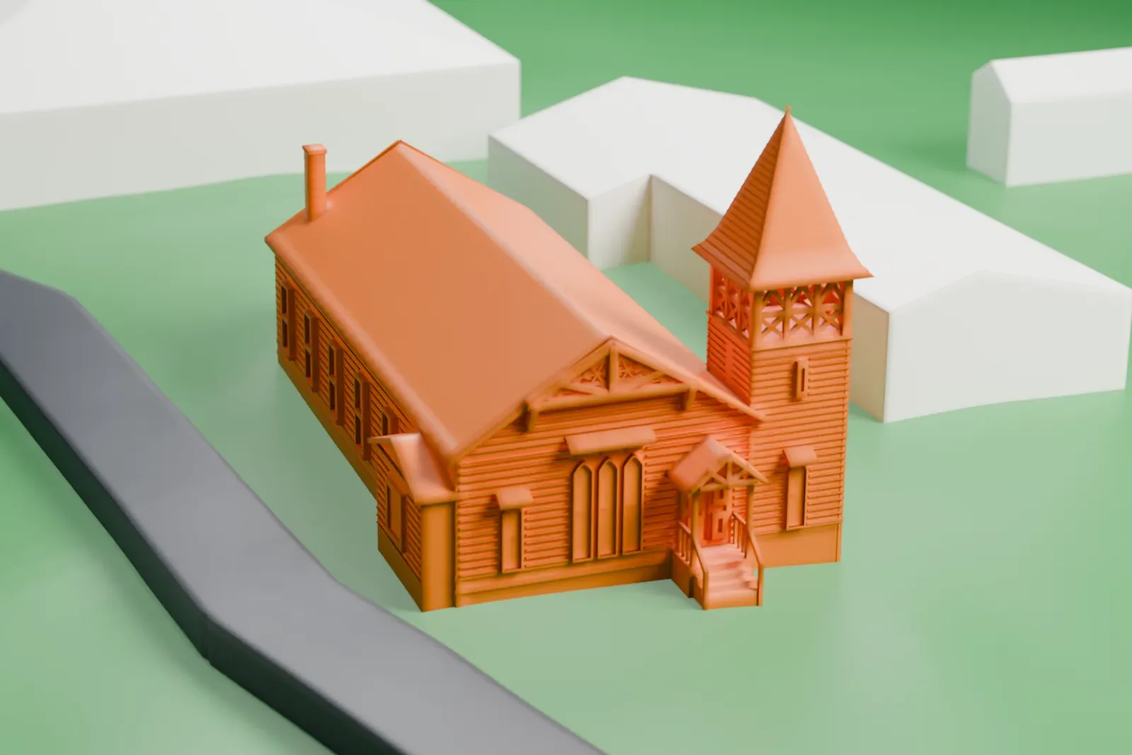 A white 3D print of the Presbyterian Church of Norwood, a church with a pointed steeple tower and a rounded end, on a green lawn beside a road with a few buildings.
