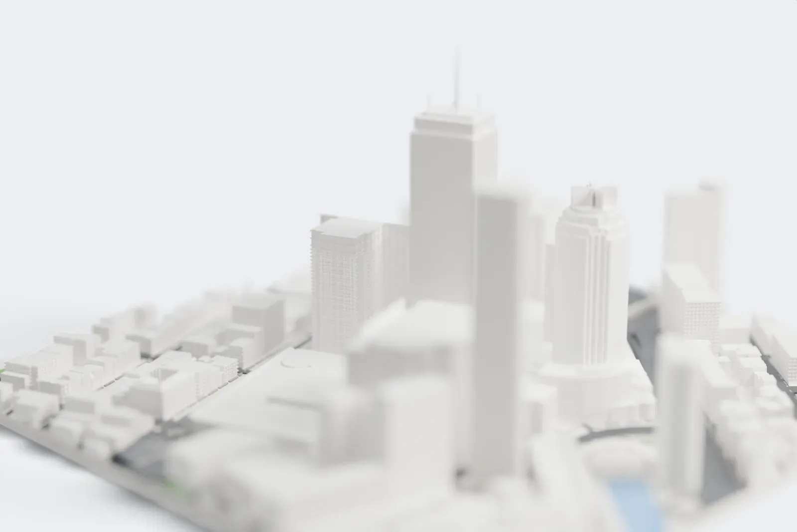 A white 3D print of the Prudential Tower, a tall rectangular tower with a flat crown and a thin radio mast, rising among dense downtown towers.