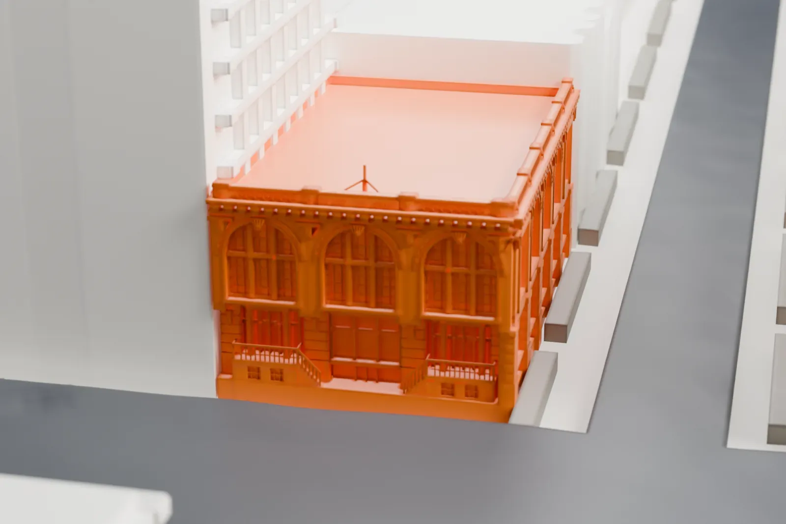 A white 3D print of Public Bath No. 7, a boxy building with tall arched windows and a carved cornice, wedged among taller neighboring buildings.