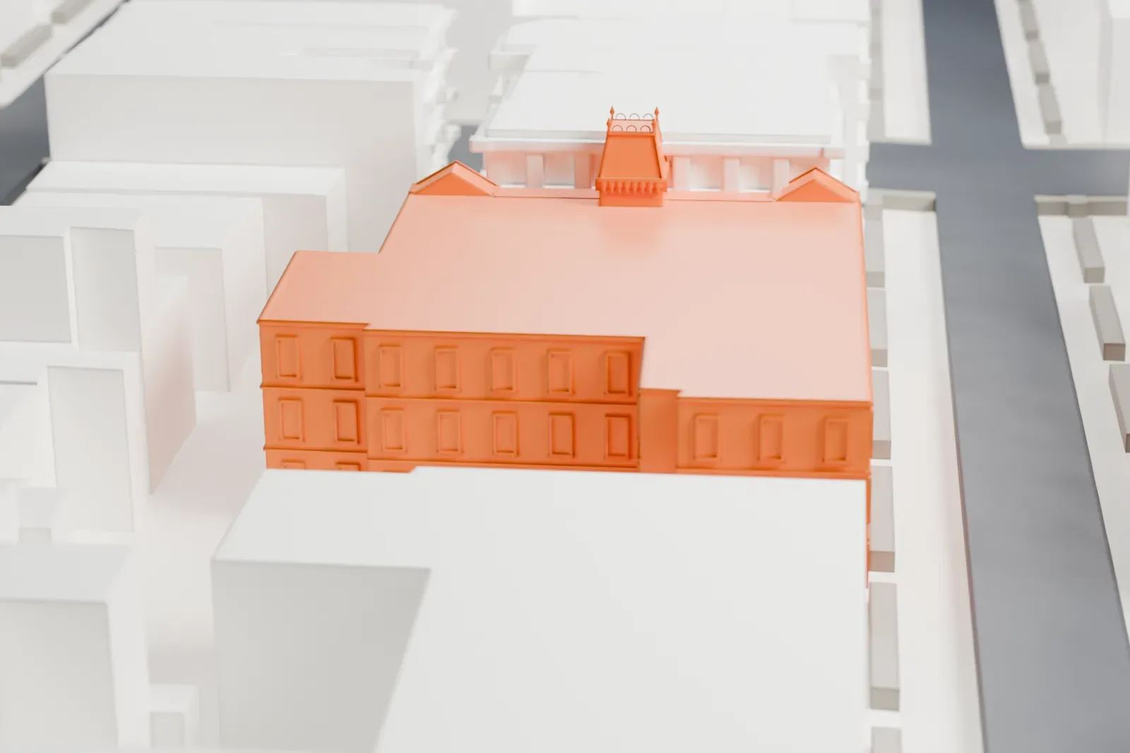 A white 3D print of Public School 71K, a wide three-story building with a small ornate tower on its roof, surrounded by taller and similar buildings on city blocks.