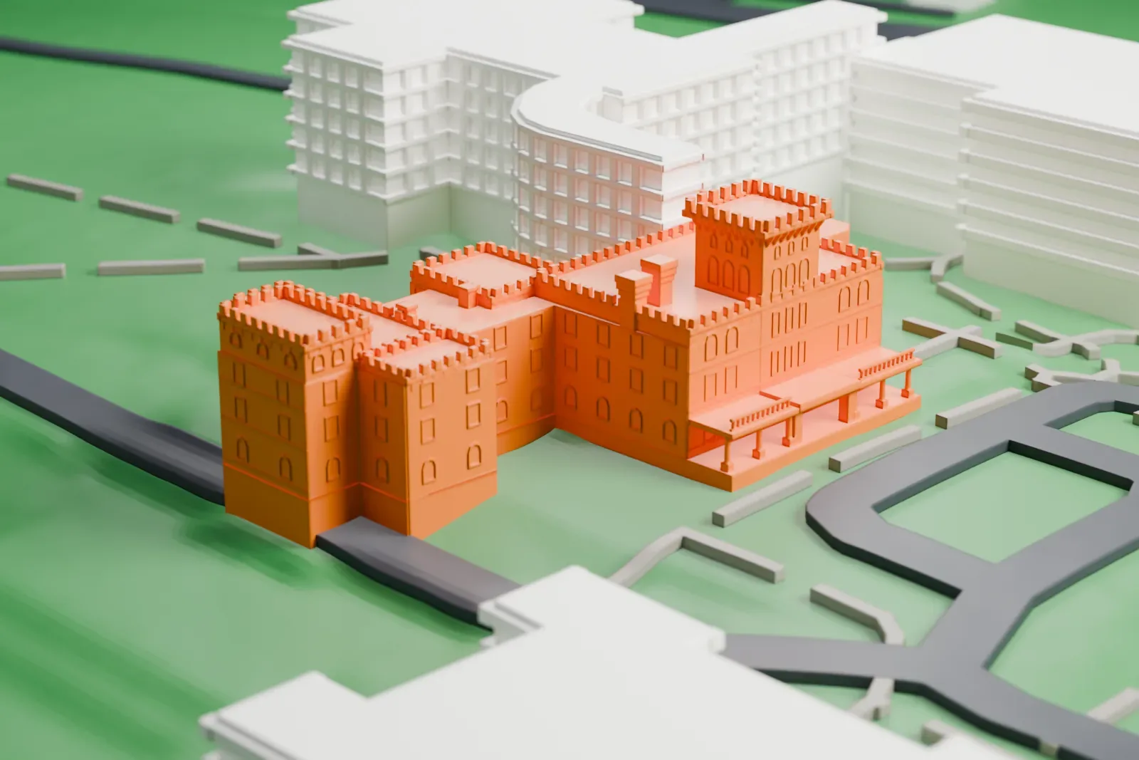 A white 3D print of Reid Hall, a castle-like building with battlemented towers, set on green lawns with campus roads and a curved modern building beside it.