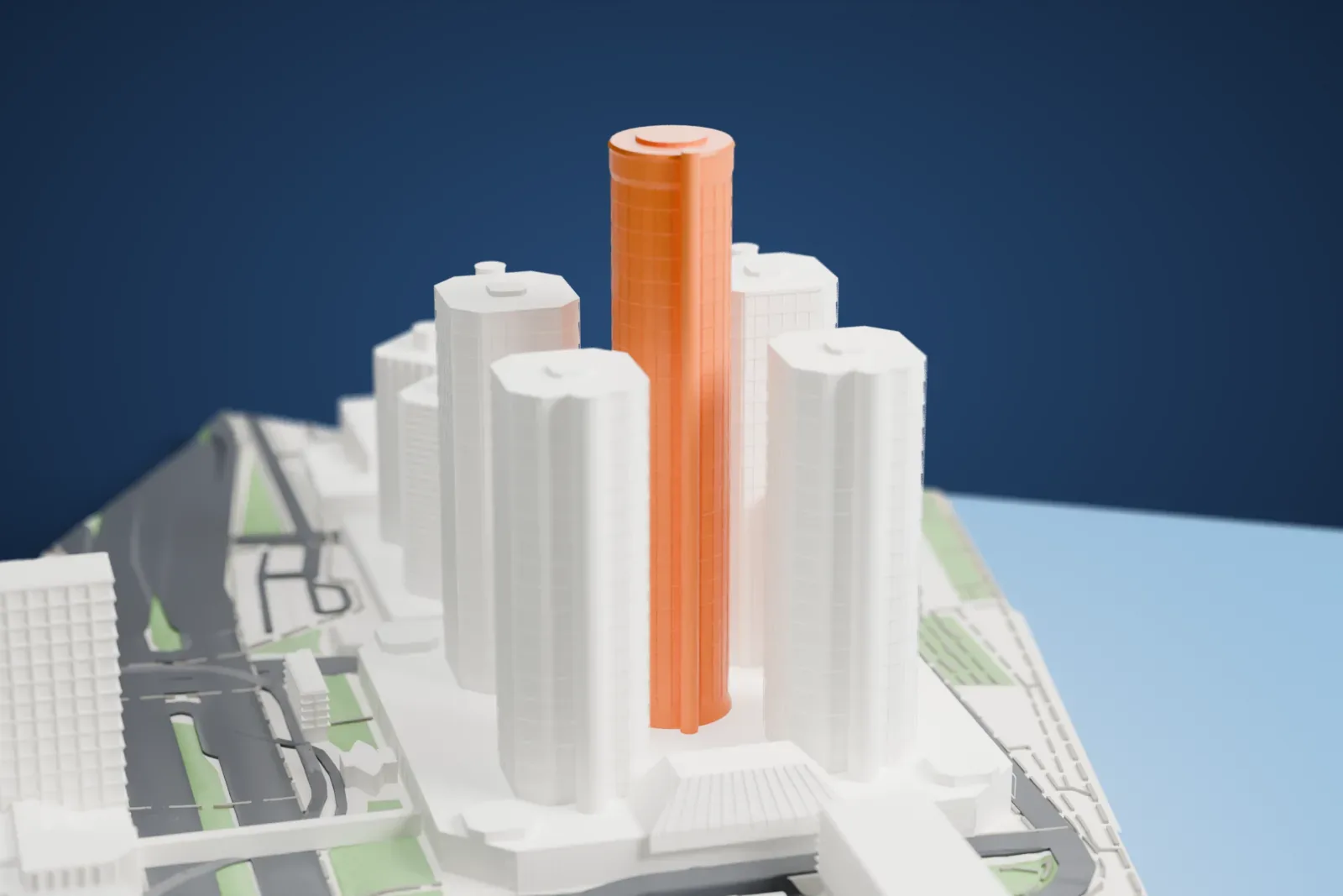A white 3D print of the Renaissance Center, a tall cylindrical tower surrounded by four shorter towers on a wide podium beside the water, with downtown buildings around it.