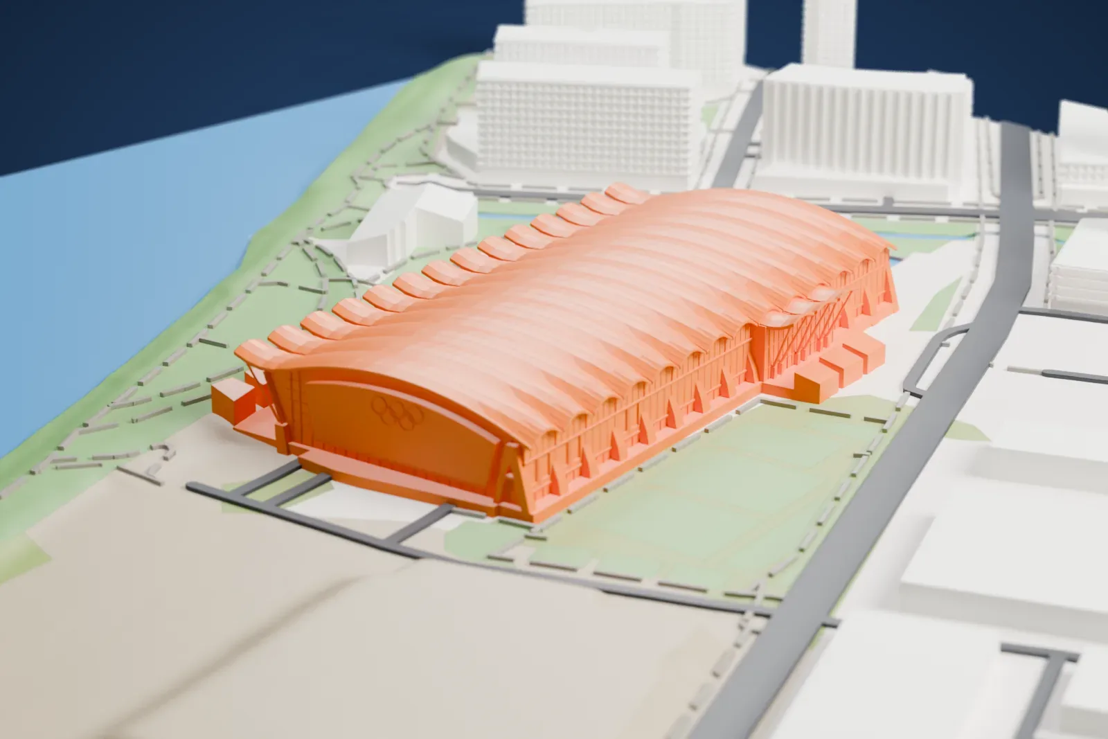 A white 3D print of the Richmond Olympic Oval, a long arena under a wave-ribbed arched roof, beside a river and a park, with multi-story buildings nearby.