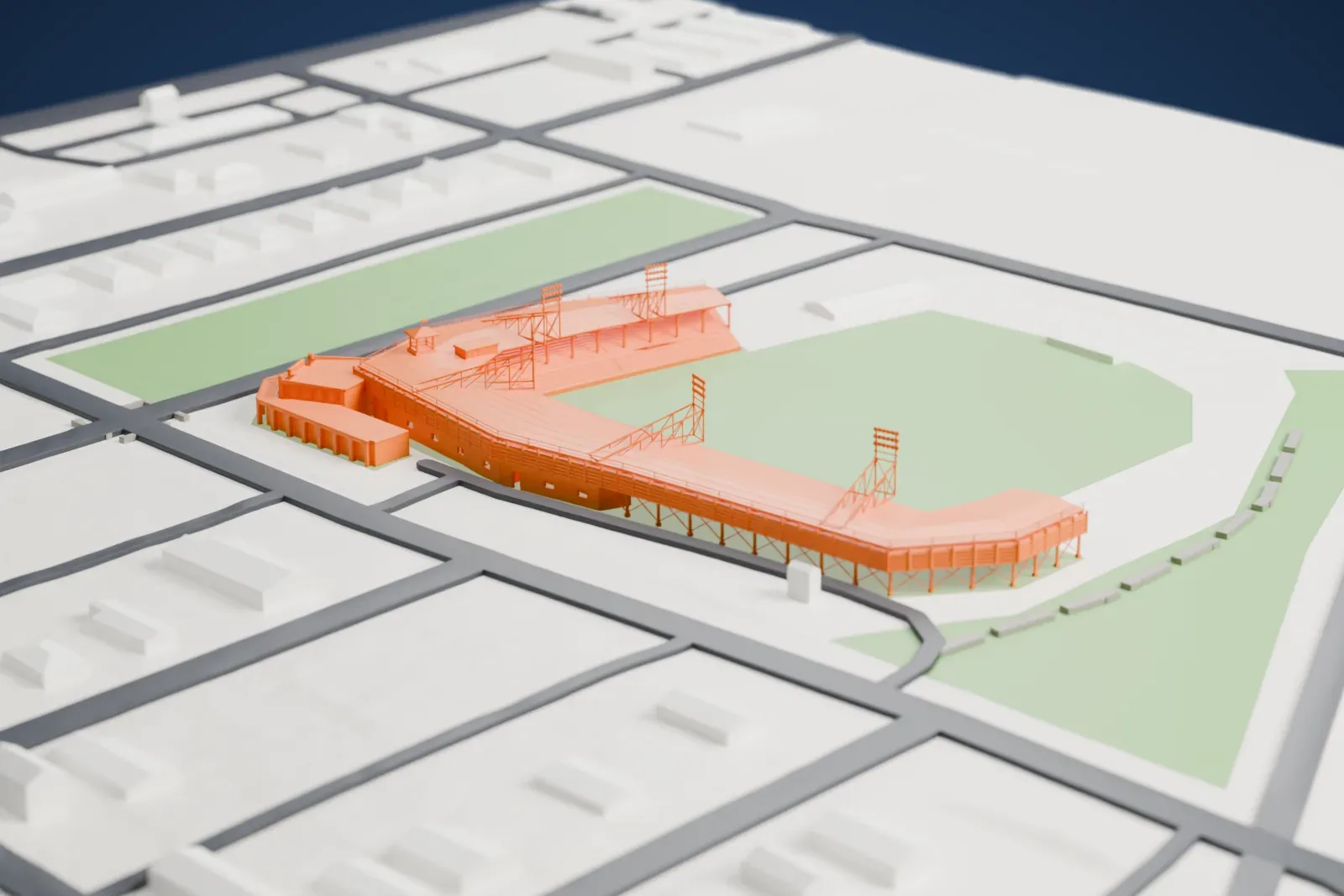 A white 3D print of Rickwood Field, a small ballpark with an angled grandstand on slim legs, light towers and an open field, set among streets, small buildings and a green strip.
