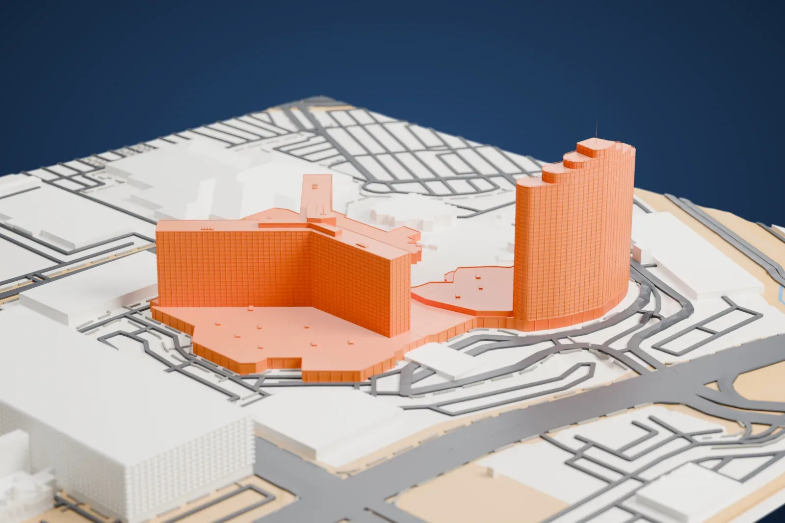 A white 3D print of the Rio Las Vegas complex with a curved tower, a branching tower, and broad low roofs surrounded by roads and neighboring buildings.