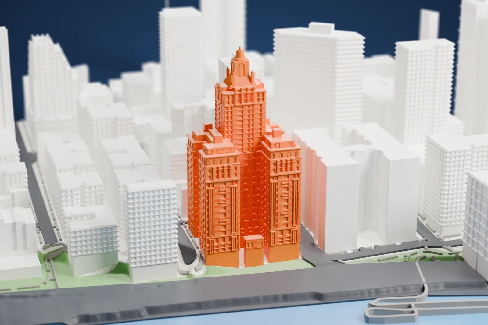 A white 3D print of River House, a tall stepped tower with a small domed lantern on top, standing beside a waterfront road and the water.
