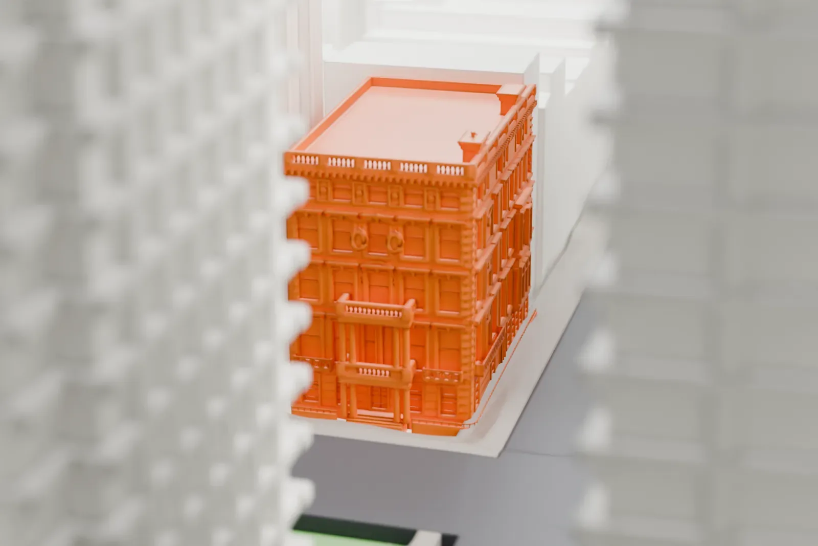 A white 3D print of the Robb House, a townhouse with a flat roof and small chimneys, closely surrounded by much taller buildings.