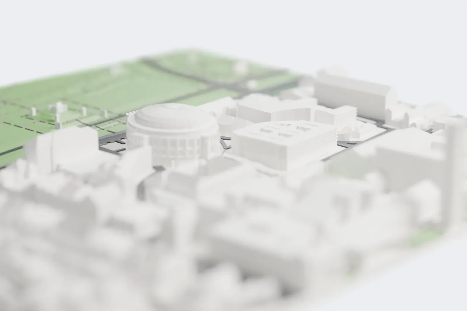 A white 3D print of the Royal Albert Hall, a round building with a ribbed dome, rings of arches and slim columns, and projecting porches, surrounded by city blocks and a nearby park.
