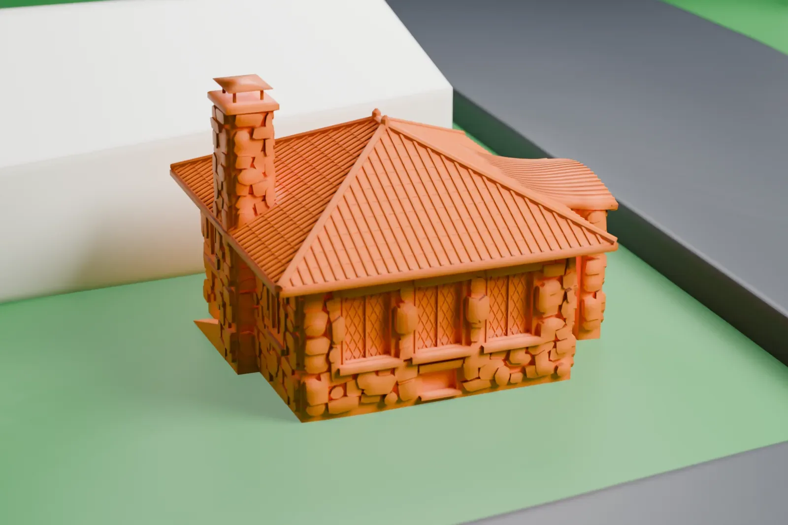 A white 3D print of the Rushmore Memorial Library, a small stone building with a hipped tiled roof and a tall chimney, on a grassy lot between roads.