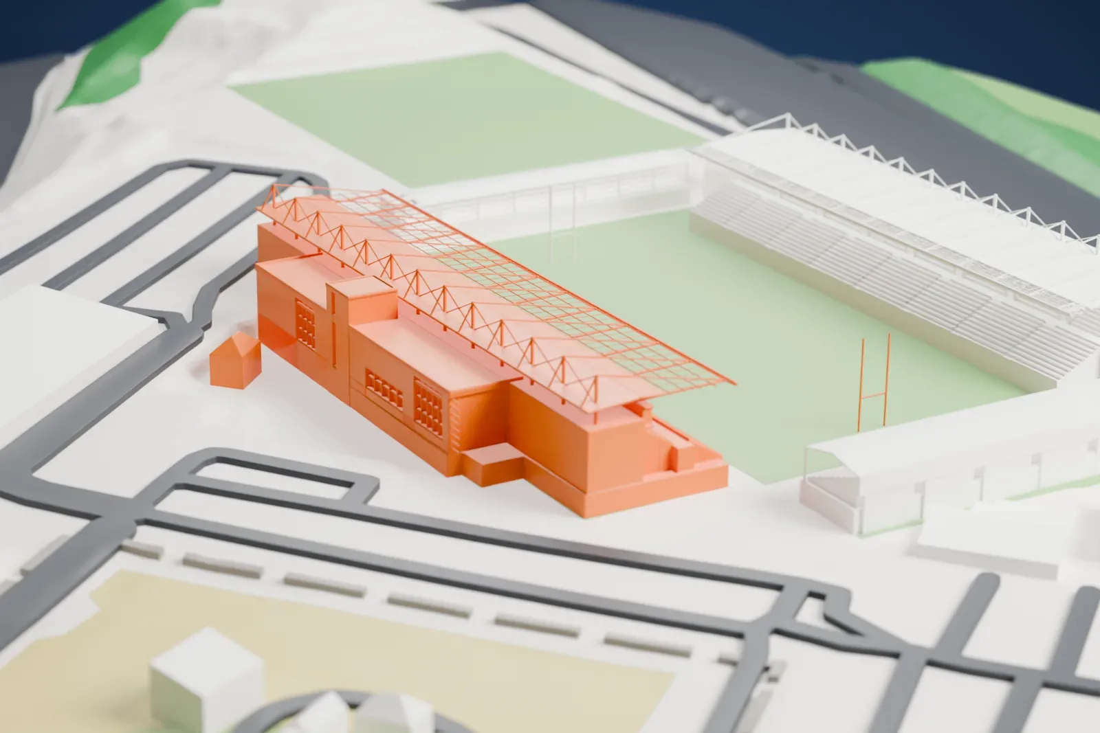 A white 3D print of Sandy Park, a rugby stadium with stands on several sides of a green pitch, beside car parks, fields and roads.