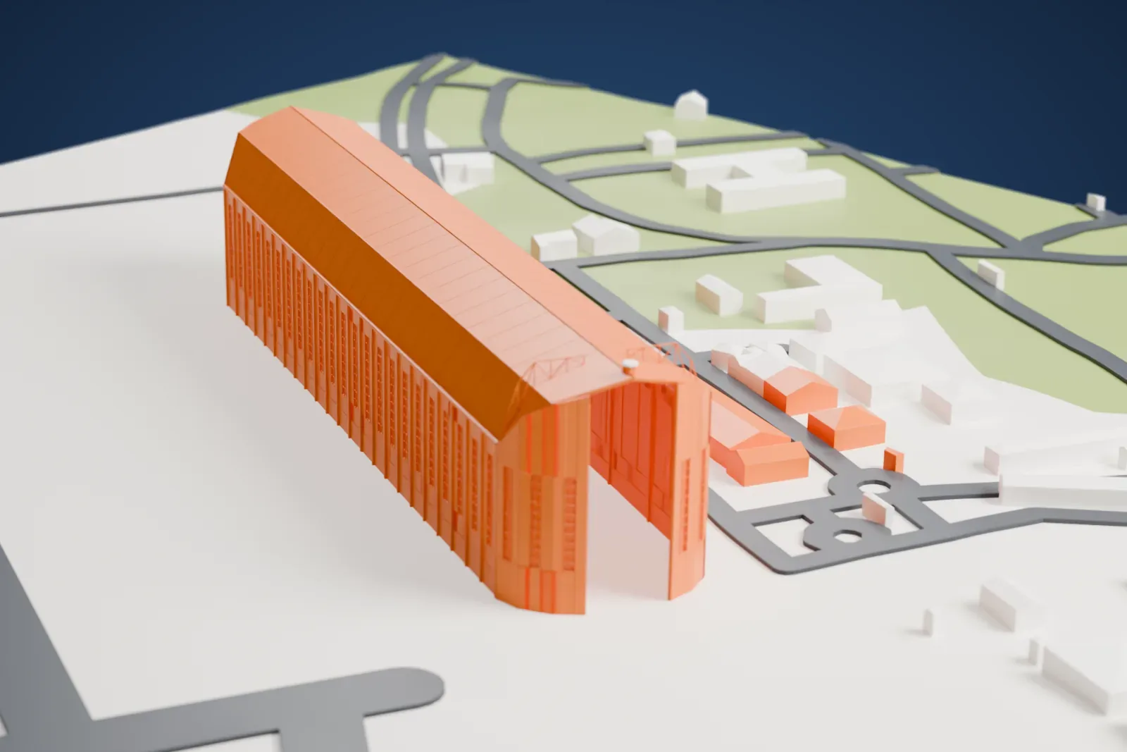 A white 3D print of the Santa Cruz Zeppelin Hangar, a very long, narrow hangar with a ridged roof and tall end doors, standing on open airfield ground beside roads and low buildings.