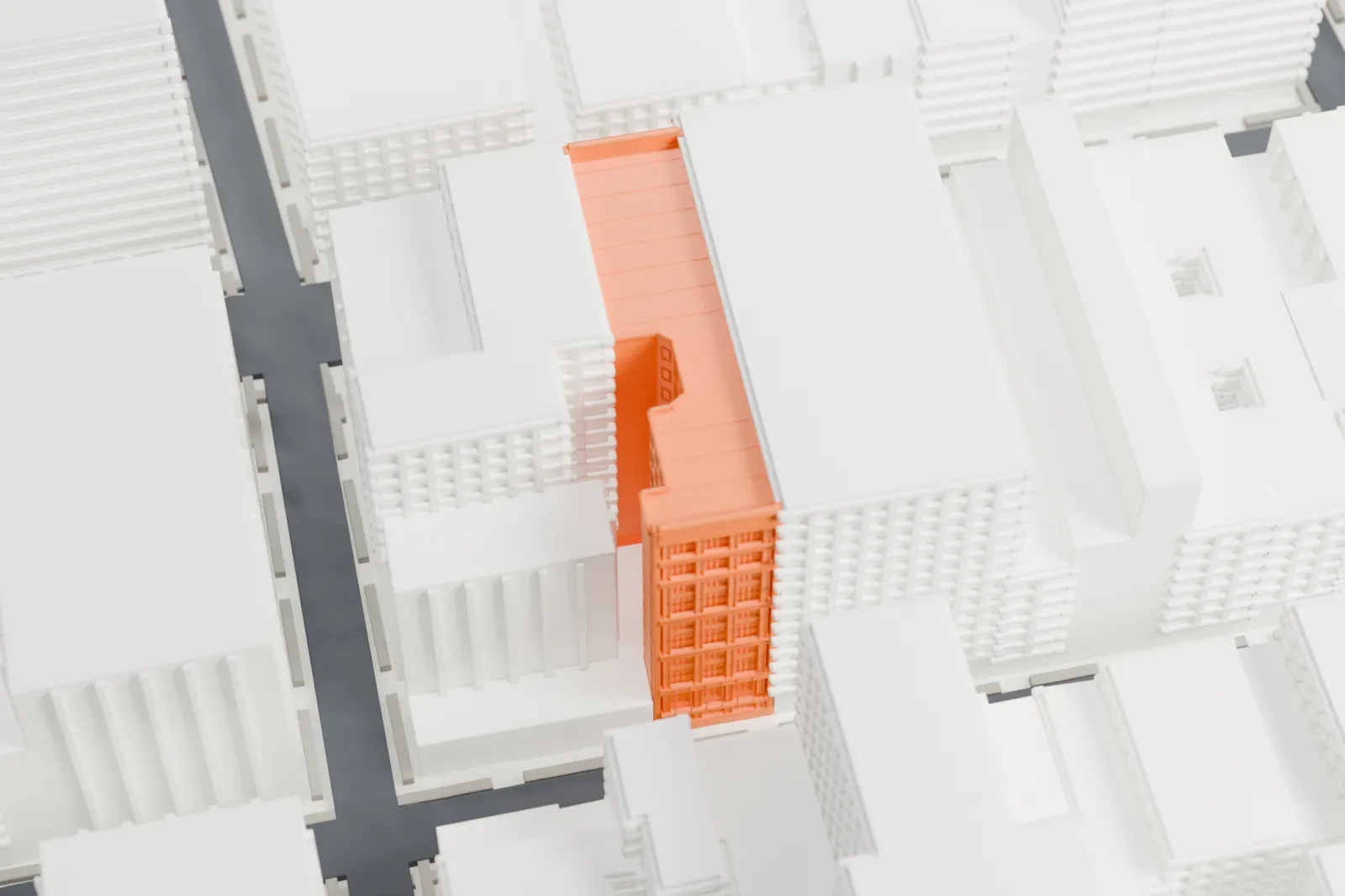 A white 3D print of the Scholastic Building, a tall gridded block standing among dense gray buildings.