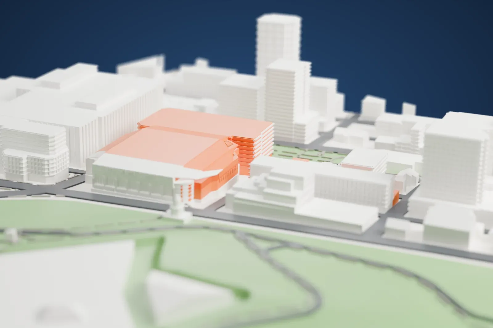 A white 3D print of Scotiabank Centre, a large arena with a broad sloped roof, standing among mid-rise buildings and streets with green ground nearby.