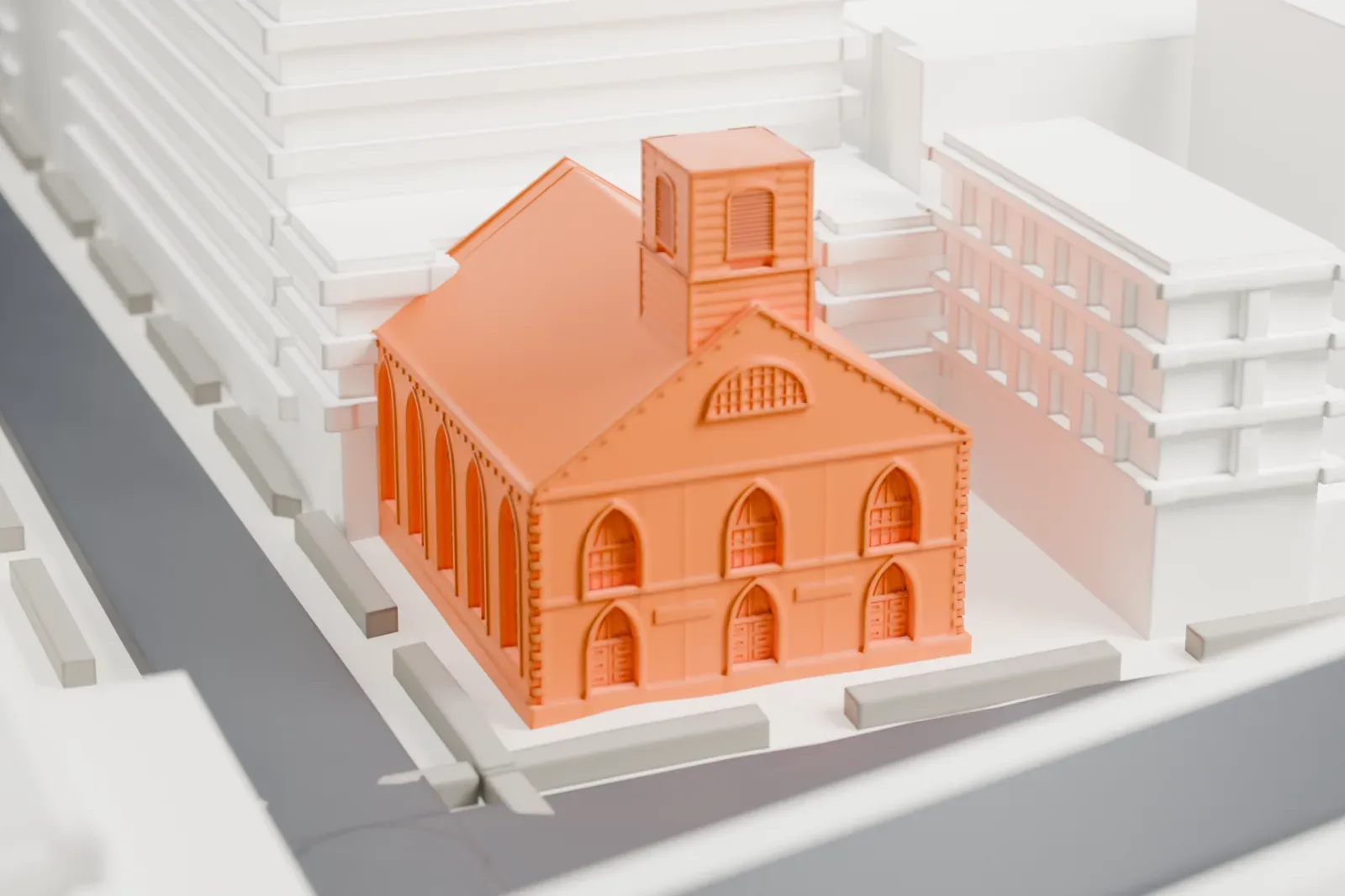 A white 3D print of the Sea and Land Church, a small gabled church among dense city blocks, with wide roads and an elevated roadway nearby.