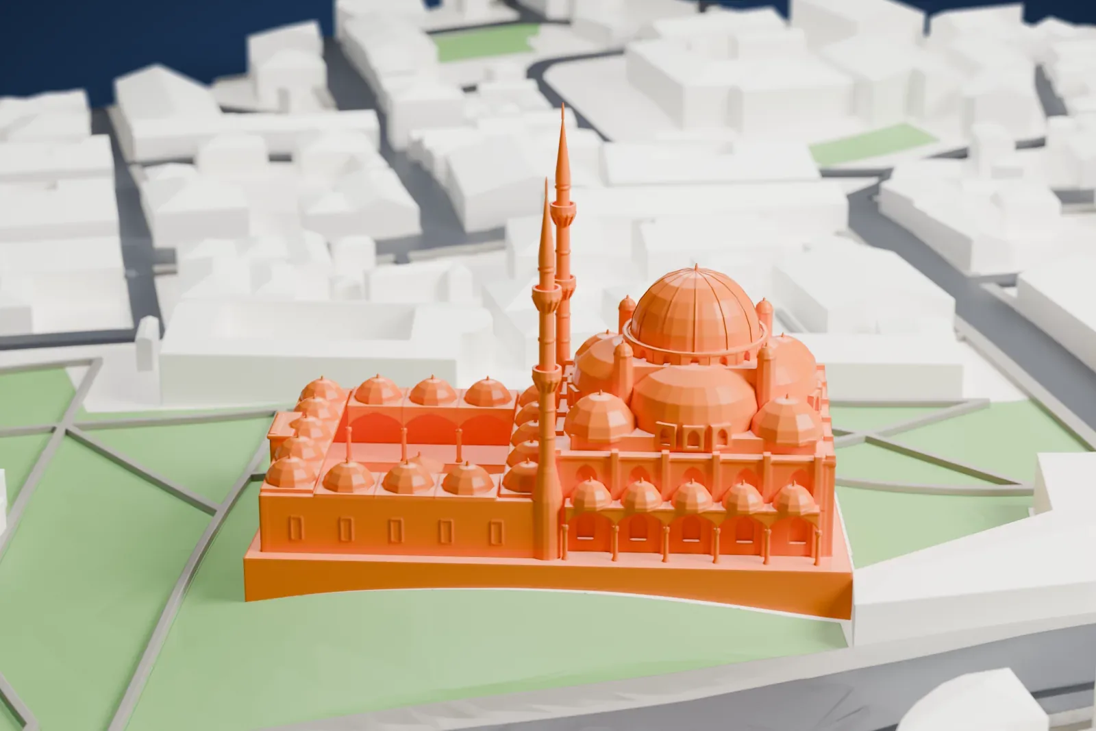 A white 3D print of the Şehzade Mosque, a large central dome with four half-domes around it and twin minarets, set among the surrounding streets and buildings of Istanbul.