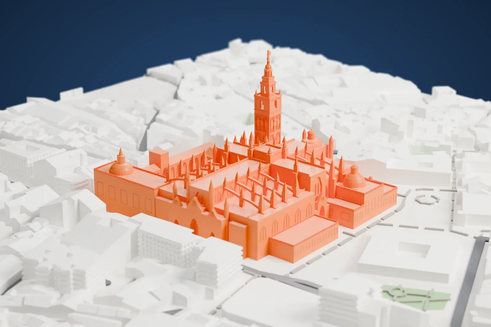 A white 3D print of Seville Cathedral, a long Gothic church with many slender pinnacles and a tall bell tower at one corner, beside an open courtyard and surrounded by dense city blocks.