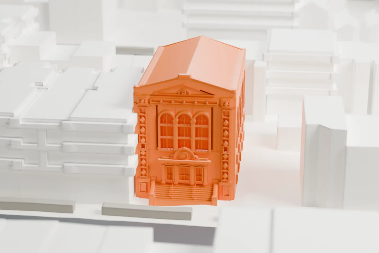 A white 3D print of the Shaari Zedek Synagogue building, a two-story hall with a gabled roof, tall arched windows and a detailed front, among neighboring buildings.