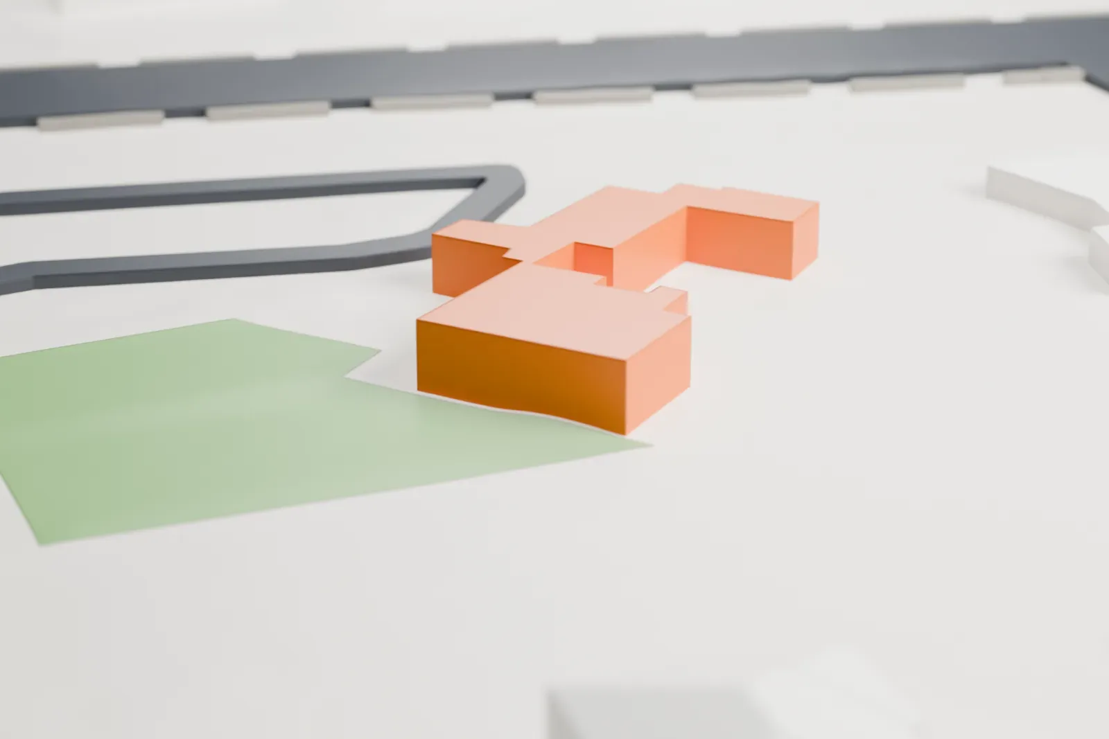 A white 3D print of the Shemer Art Center and Museum, a low tile-roofed building with courtyards and a porch, on open ground beside a patch of green.
