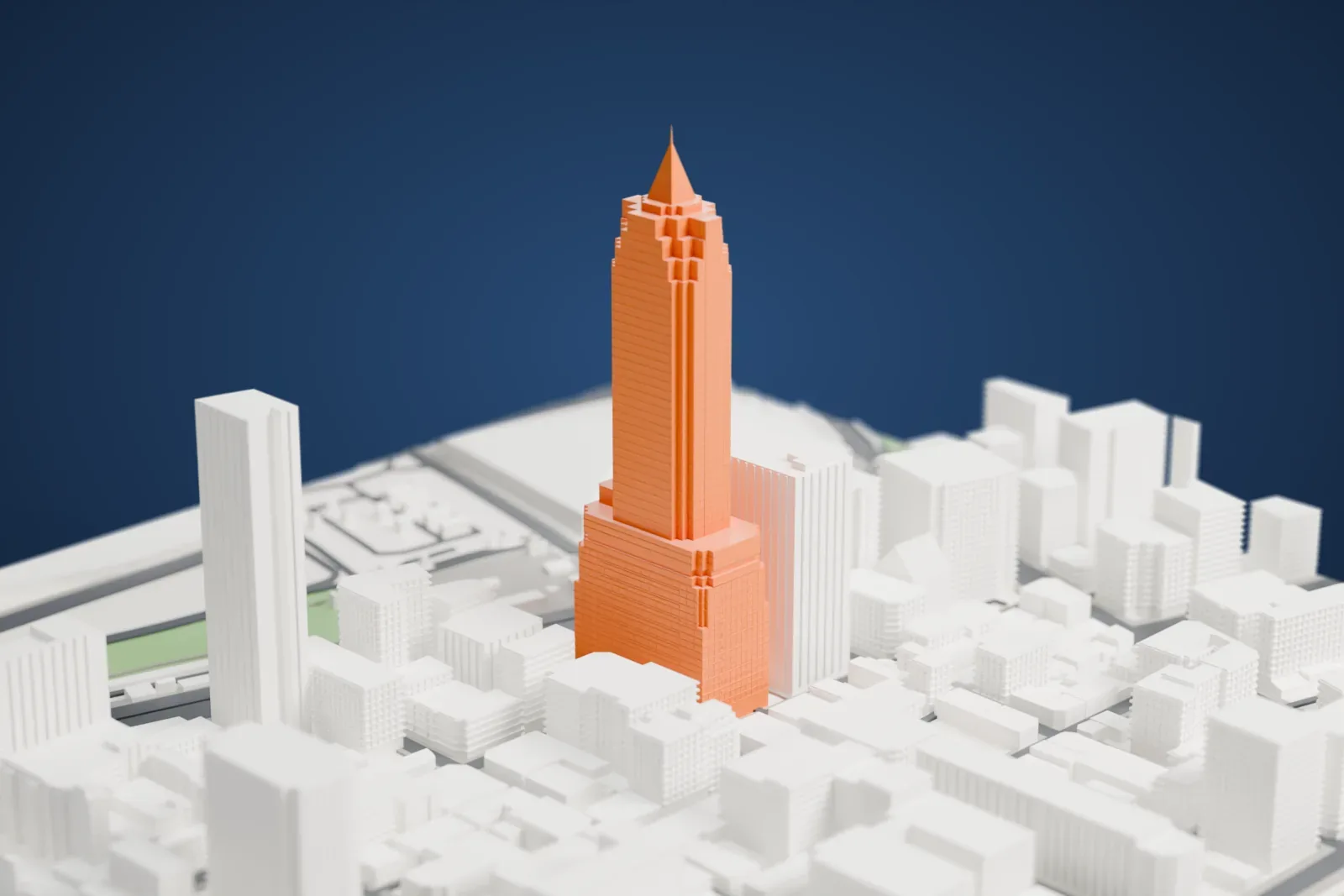 A white 3D print of the Shin Kong Life Tower, a tall slender tower topped by a pyramid, among surrounding streets and buildings.