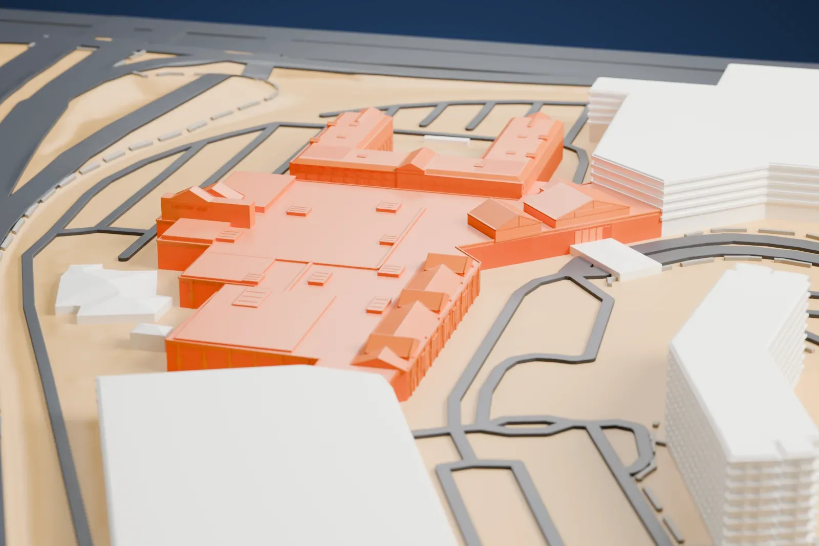 A white 3D print of the Silverton complex with a broad roof, small roof peaks, projecting wings, nearby buildings, and surrounding roads including a wide divided roadway.
