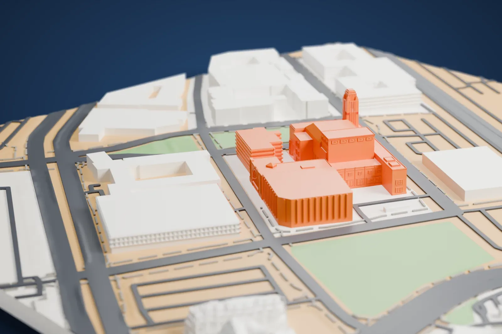 A white 3D print of the Smith Center for the Performing Arts, a stepped block building with a tall slim tower at one corner, surrounded by roads, lawns and low buildings.