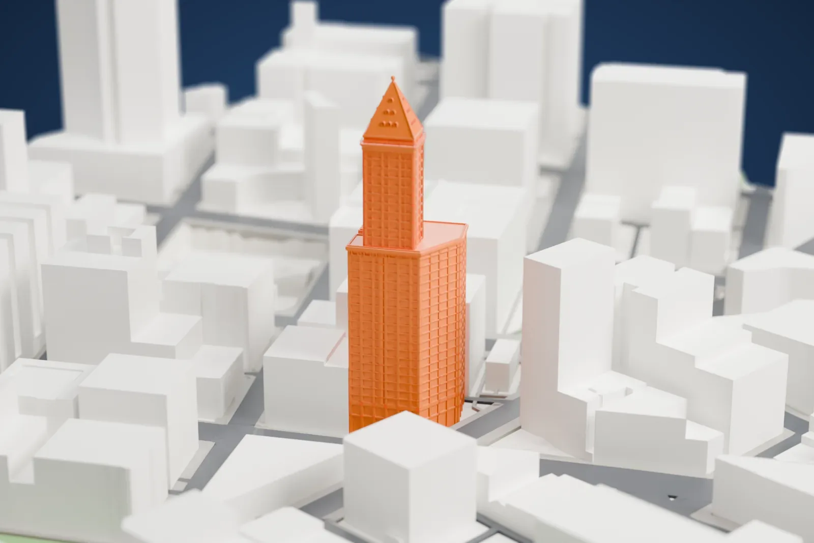 A white 3D print of the Smith Tower, its white shaft rising above the surrounding buildings of Pioneer Square in Seattle.