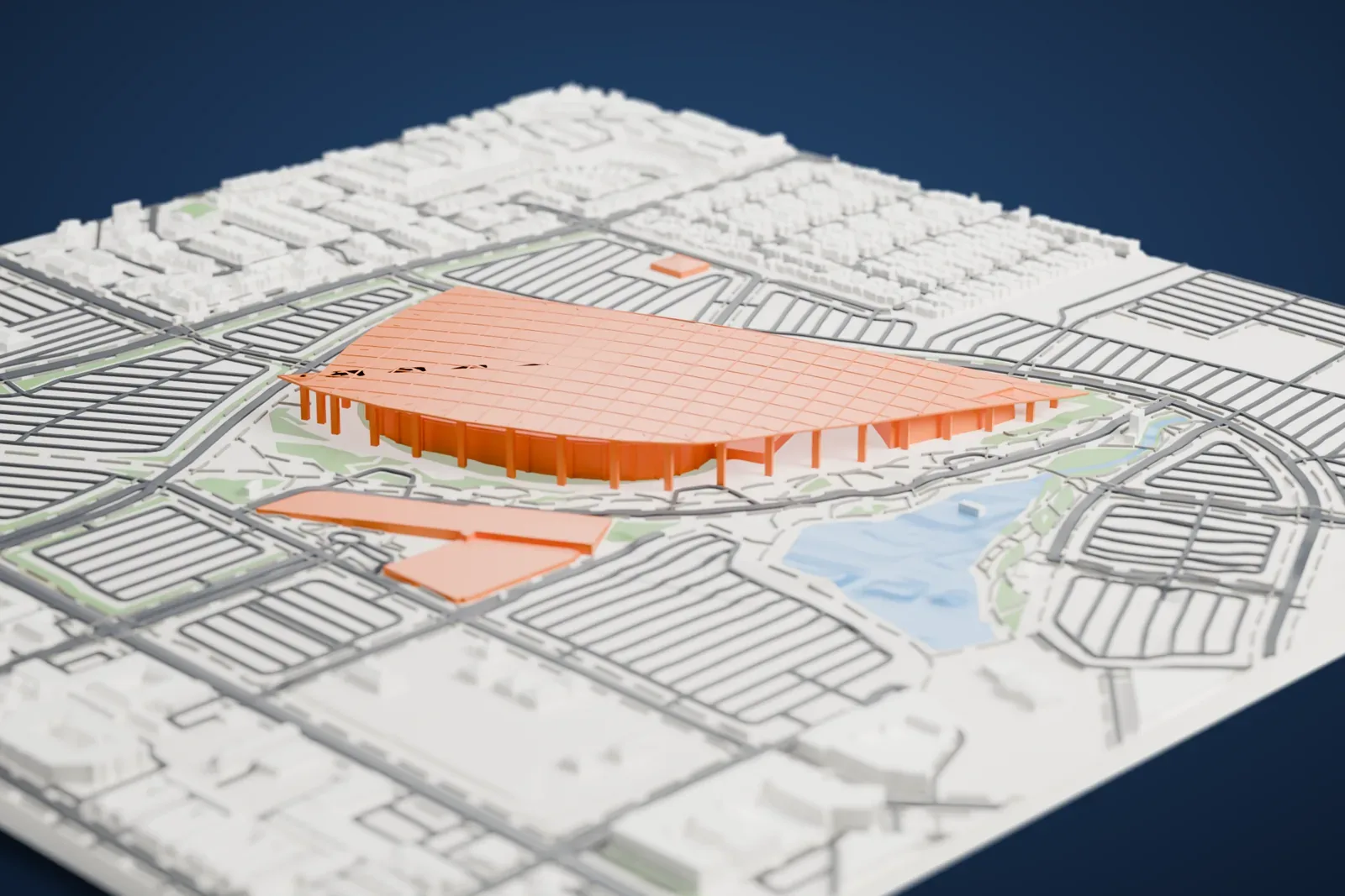 A white 3D print of SoFi Stadium, a broad curved roof canopy on rows of slim columns, surrounded by striped parking lots, roads, a lake and neighborhoods of small buildings.