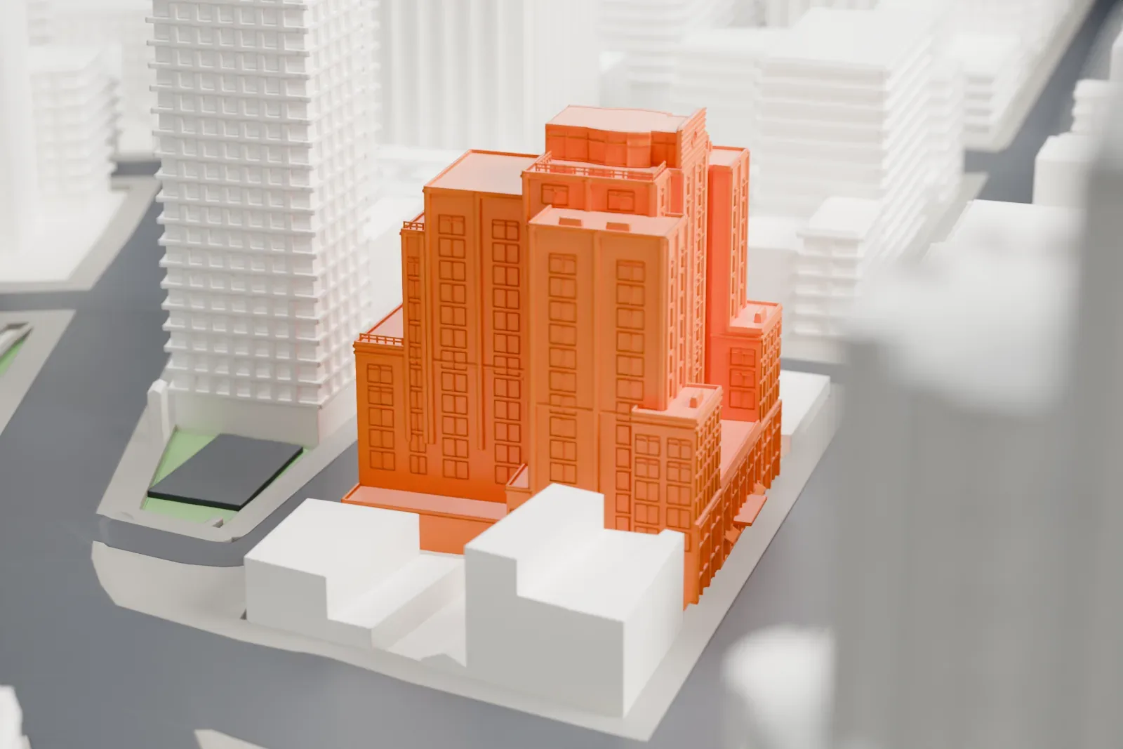 A white 3D print of the Soho Grand Hotel, a stepped tower with rows of tall windows and a curved top, tightly surrounded by taller buildings and city streets.